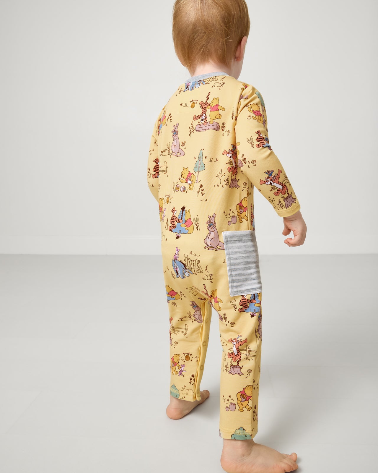 Back side of child wearing the Disney Playtime With Pooh Henley Romper