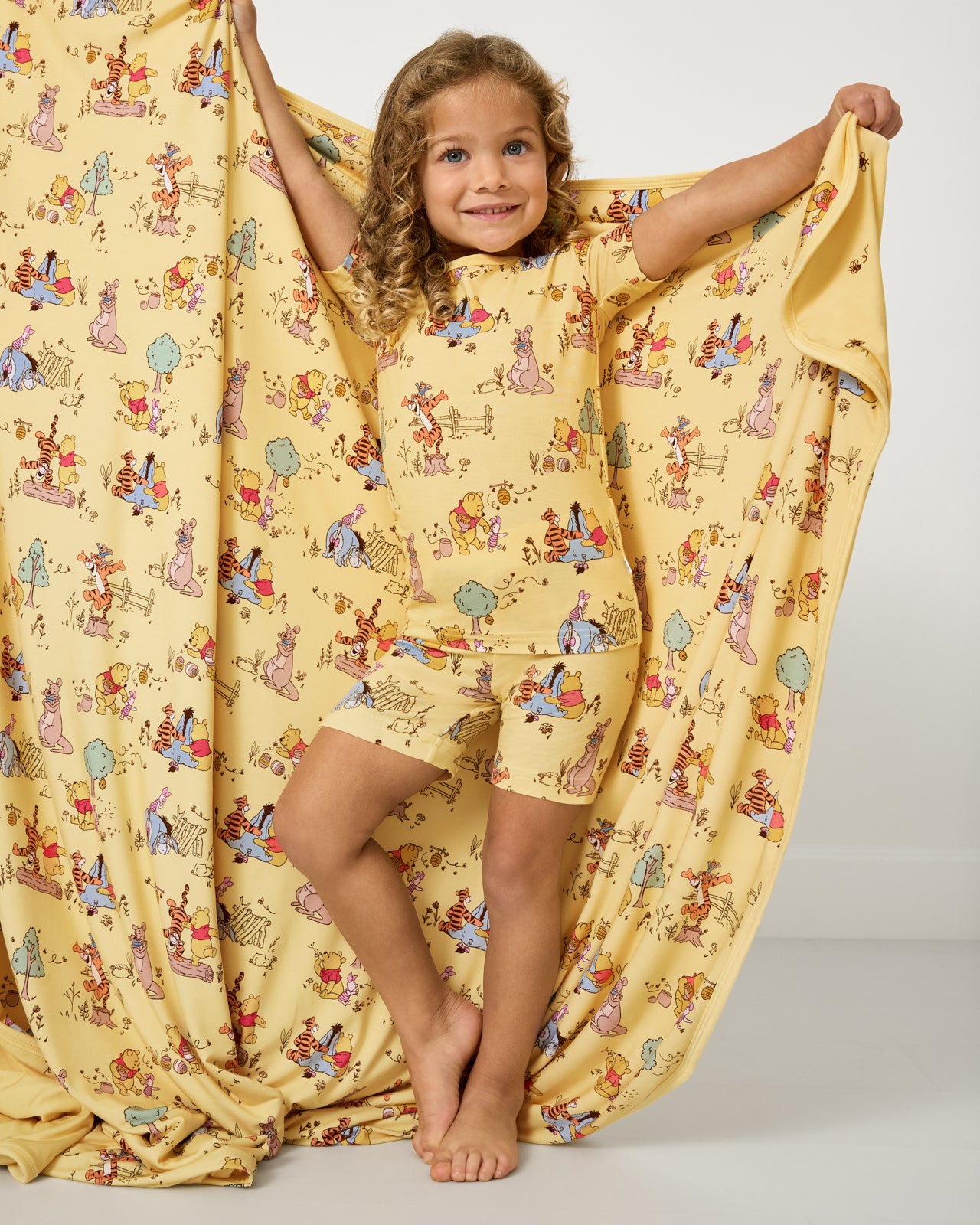 Girl holding up the Disney Playtime With Pooh Large Cloud Blanket®