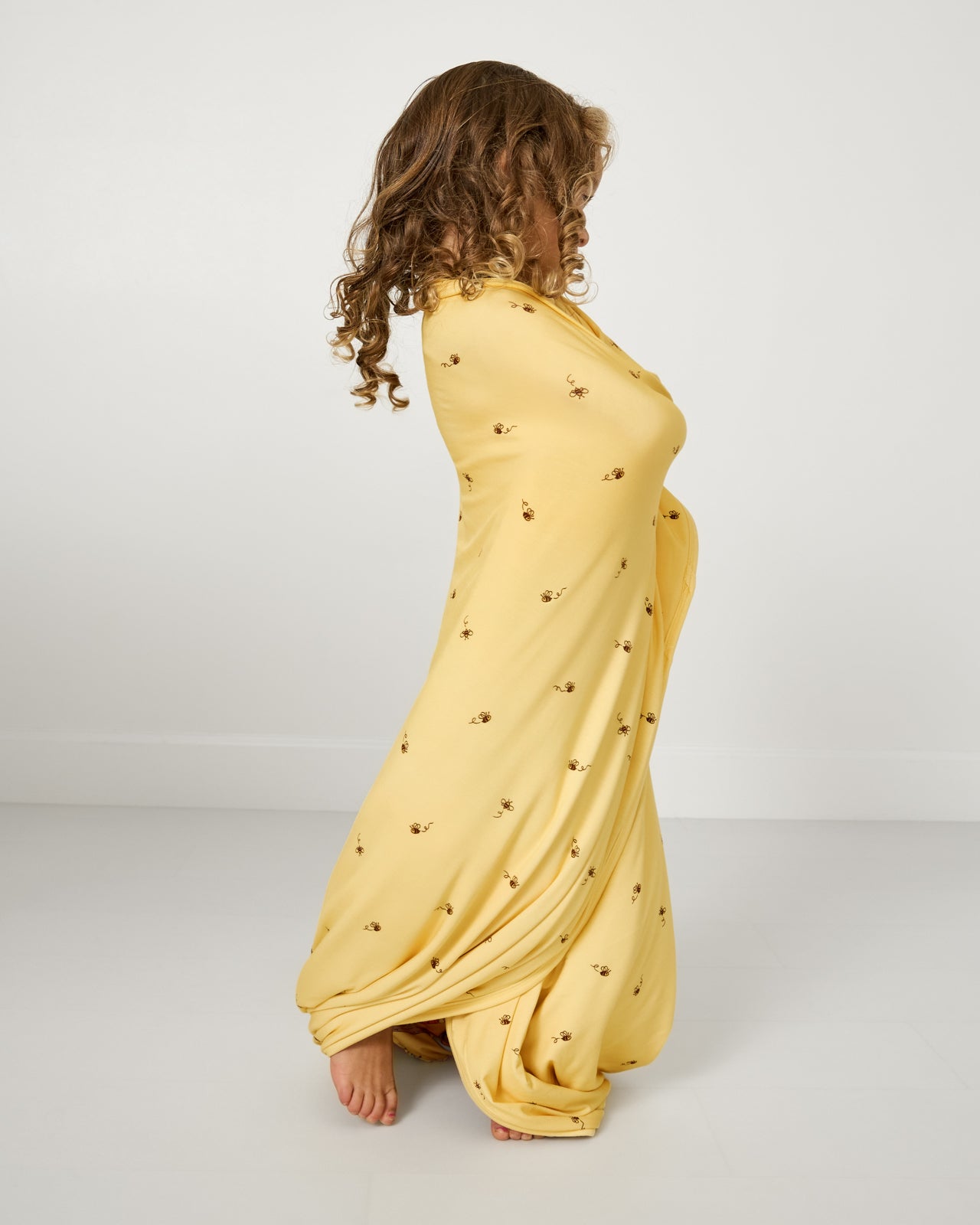 Standing girl wrapped in the Disney Playtime With Pooh Large Cloud Blanket®