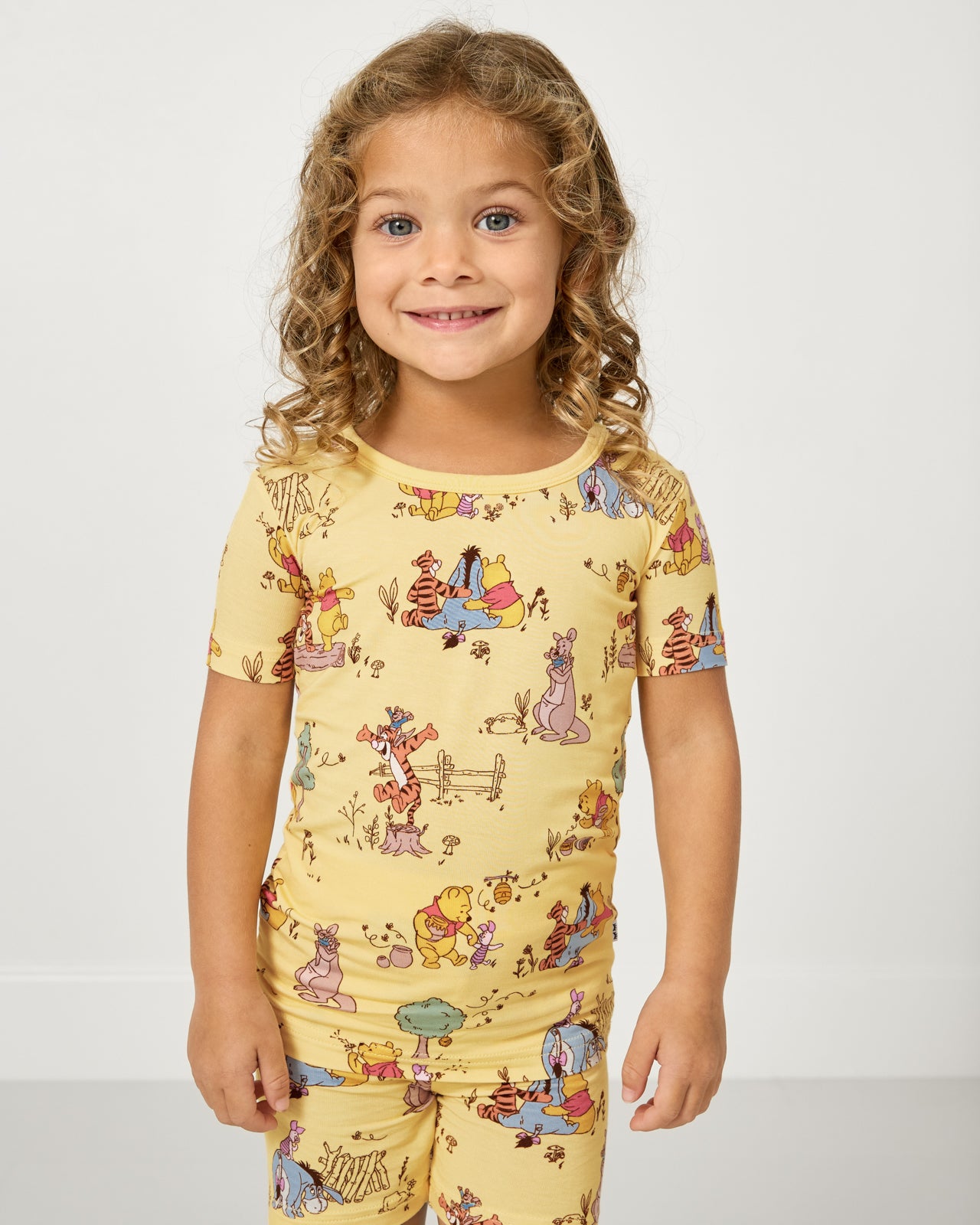 Close up of girl wearing the Disney Playtime With Pooh Two-Piece Short Sleeve & Shorts Pajama Set