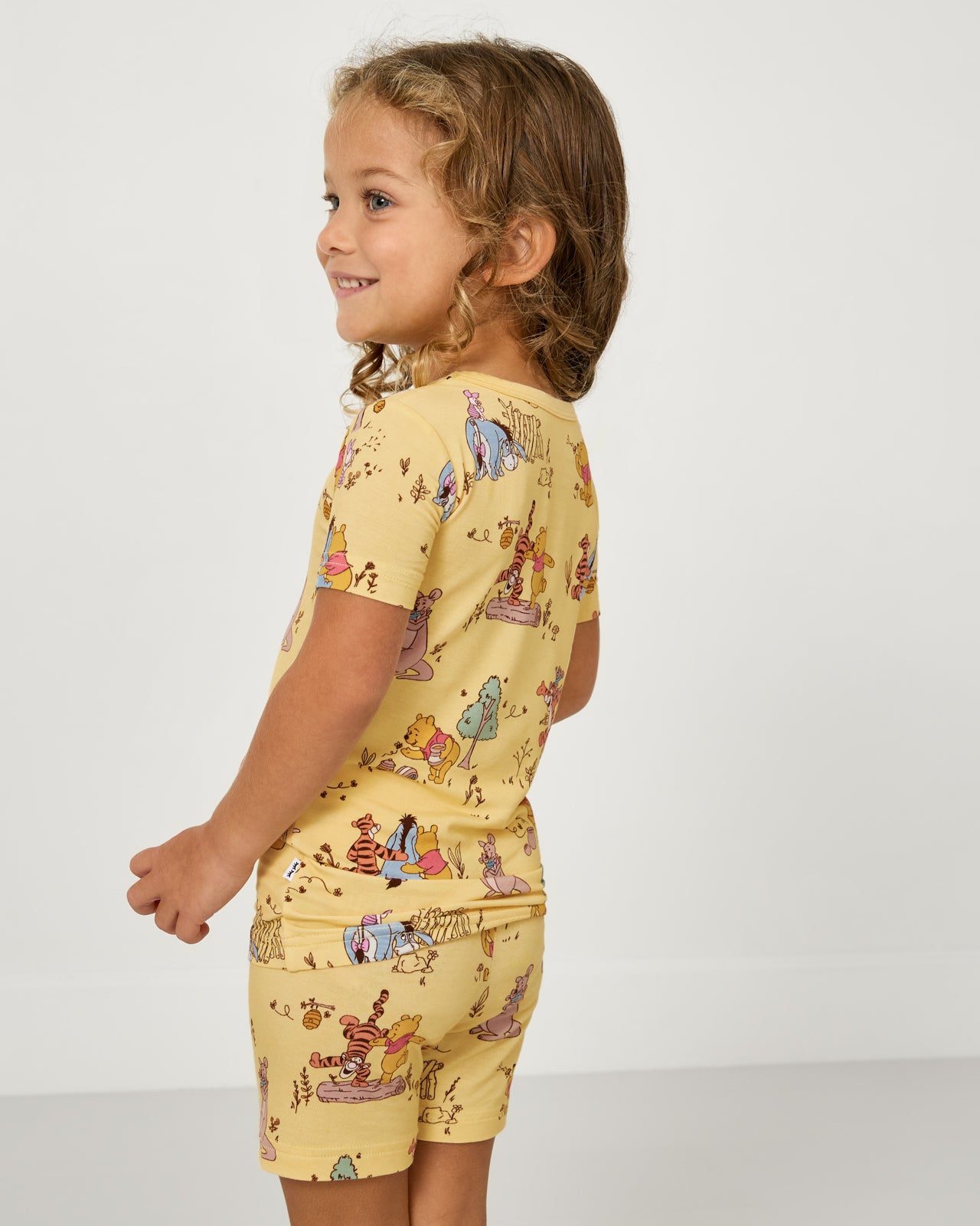 Back view of child wearing the Disney Playtime With Pooh Two-Piece Short Sleeve & Shorts Pajama Set