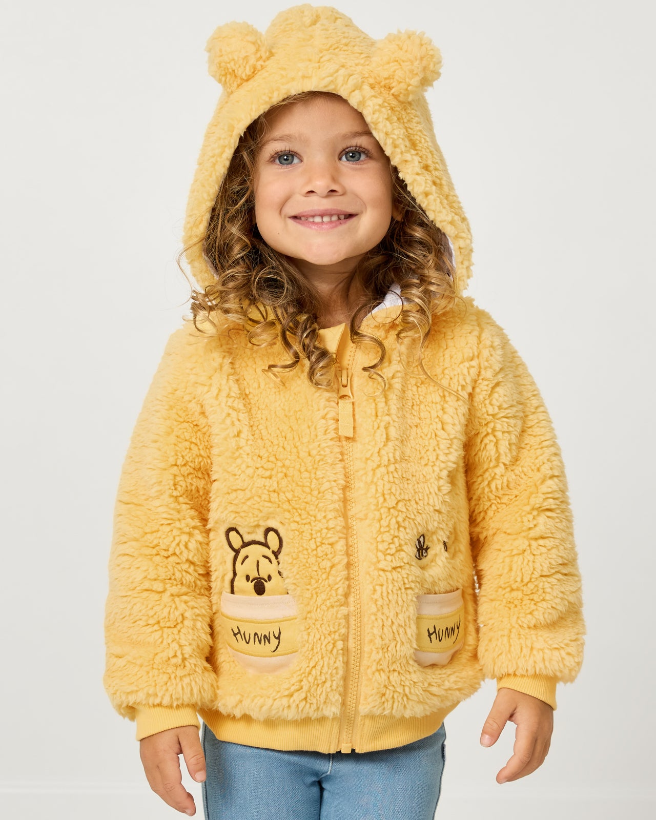 Girl wearing the Disney Winnie the Pooh Sherpa Zip Hoodie with the hood on