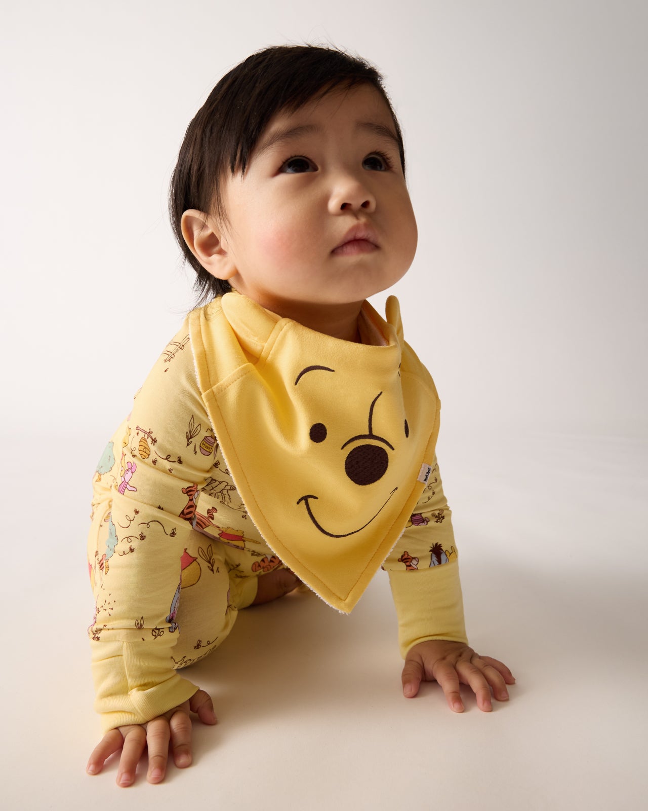 Crawling baby wearing the Disney Winnie The Pooh Bandana Bib