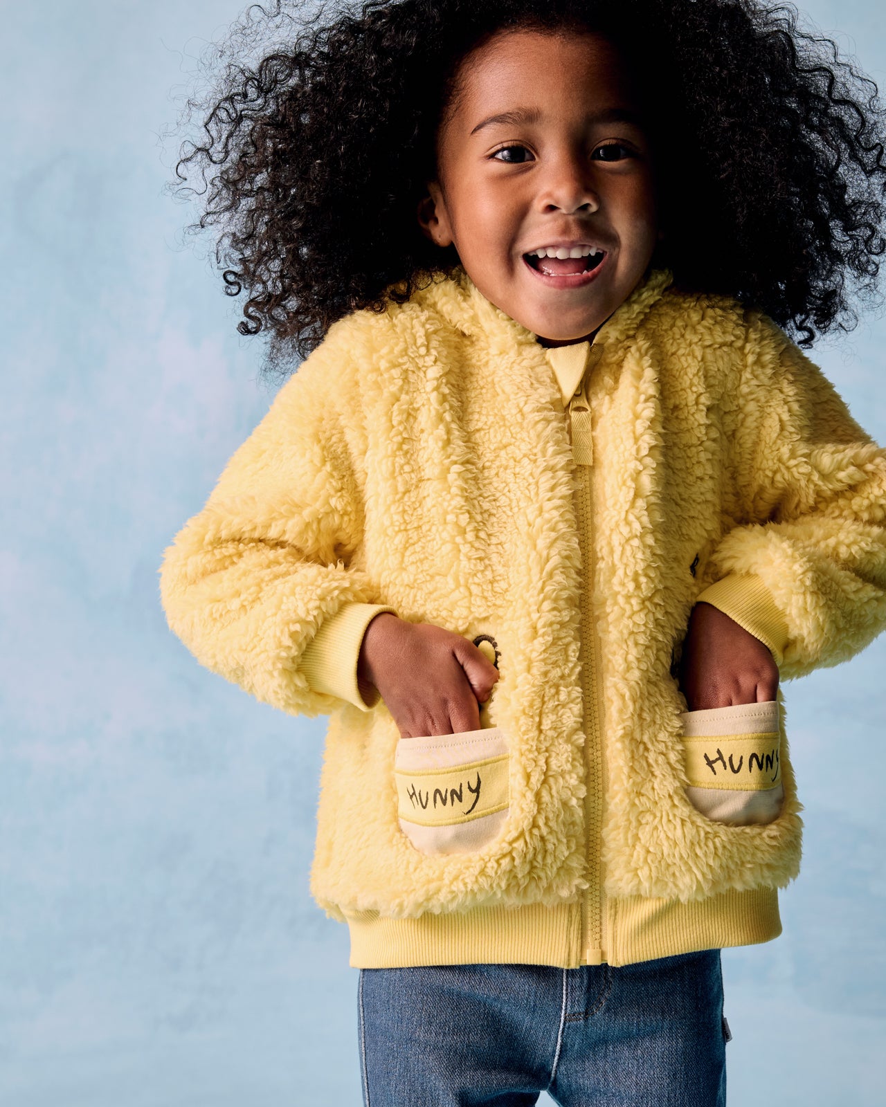 Girl wearing the Disney Winnie the Pooh Sherpa Zip Hoodie with her hands in the pockets