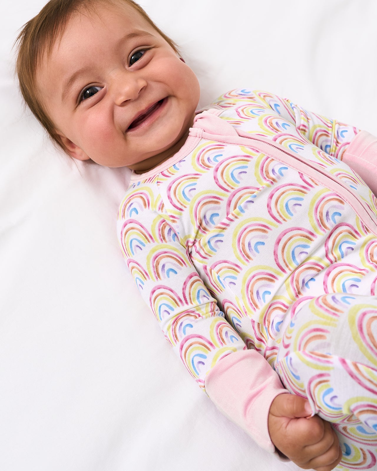 Close up of baby wearing the Pastel Rainbows Zippy