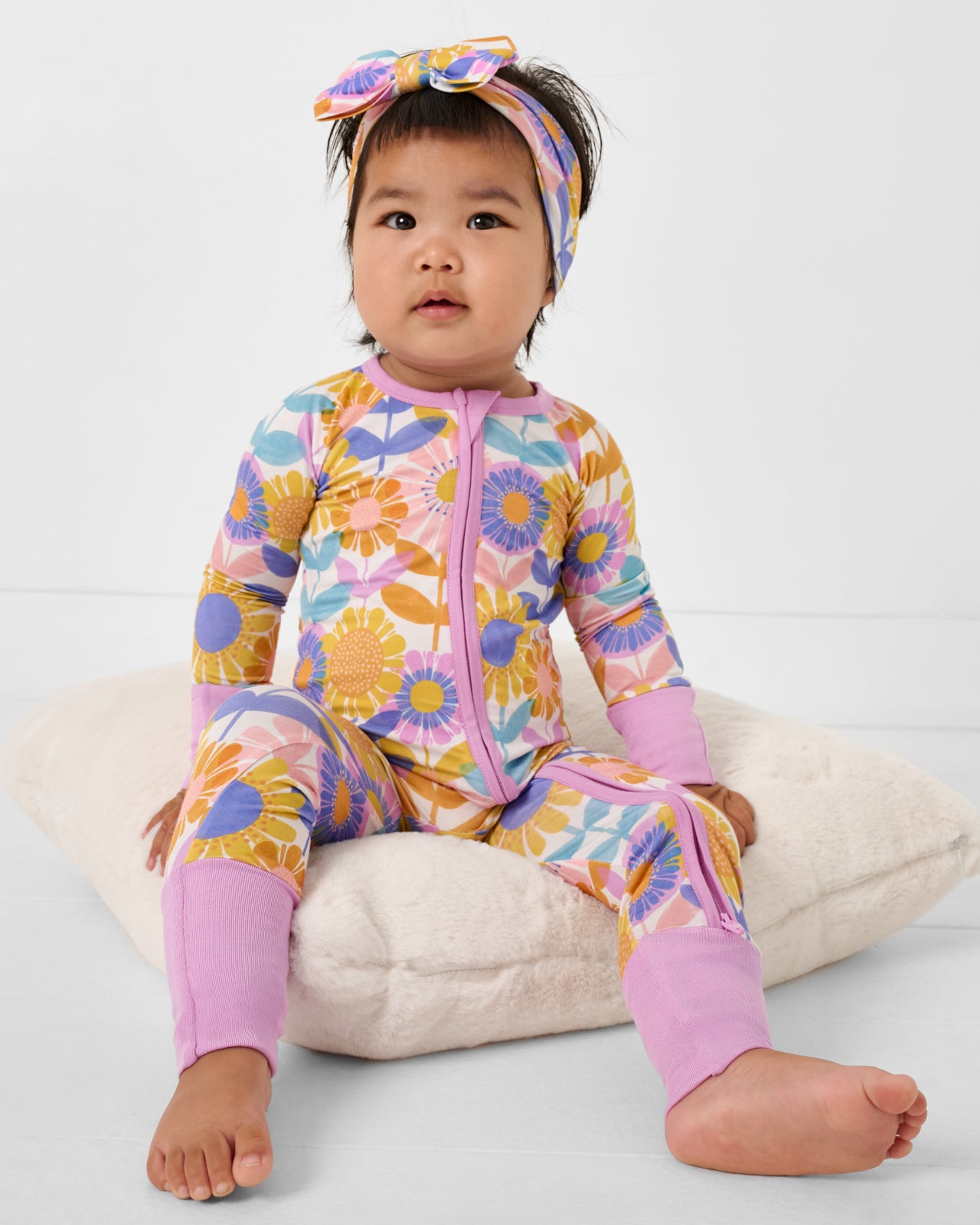Sitting baby wearing the Petal Power Zippy