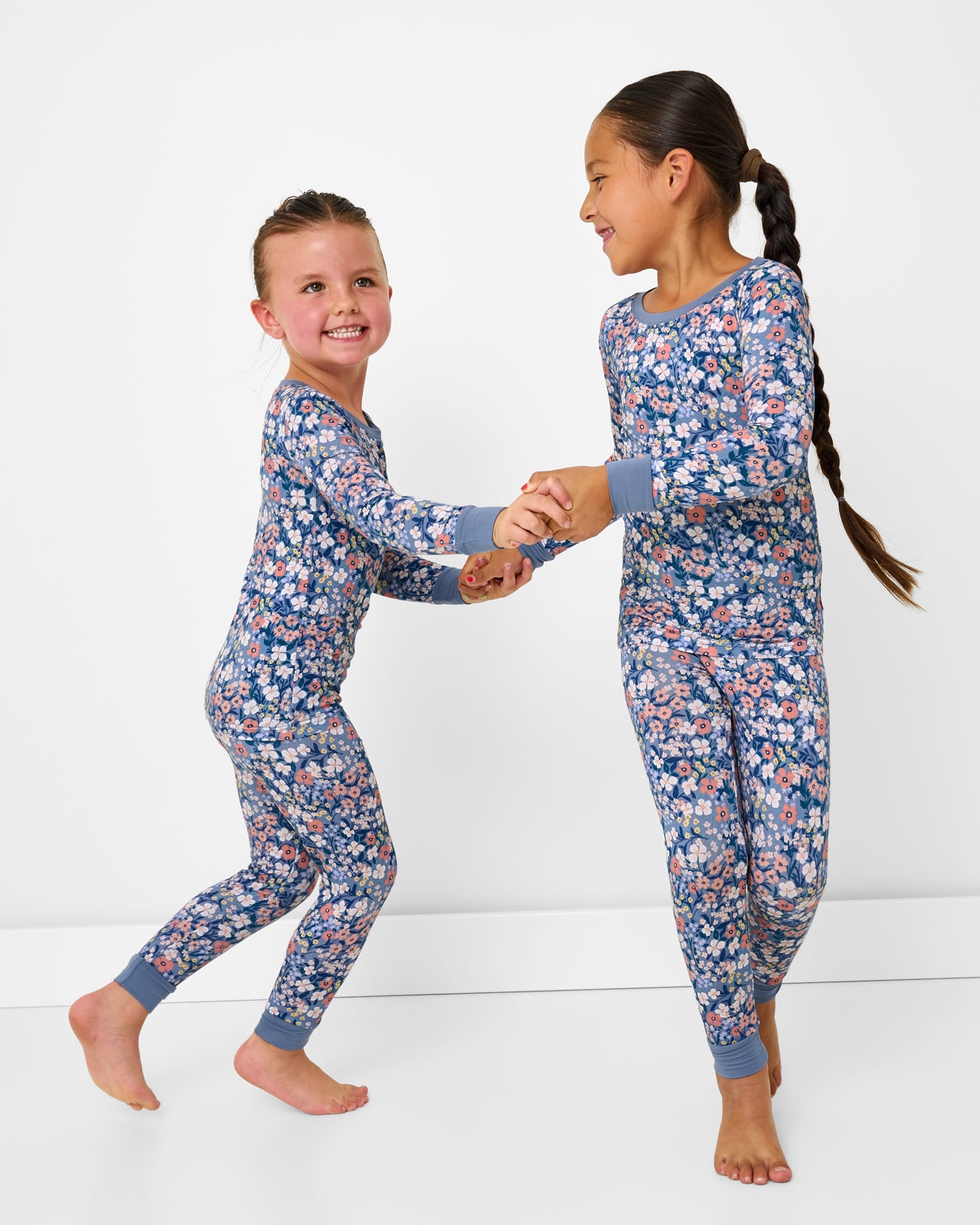 Two kids wearing matching Petite Petals Two-Piece Pajama Set