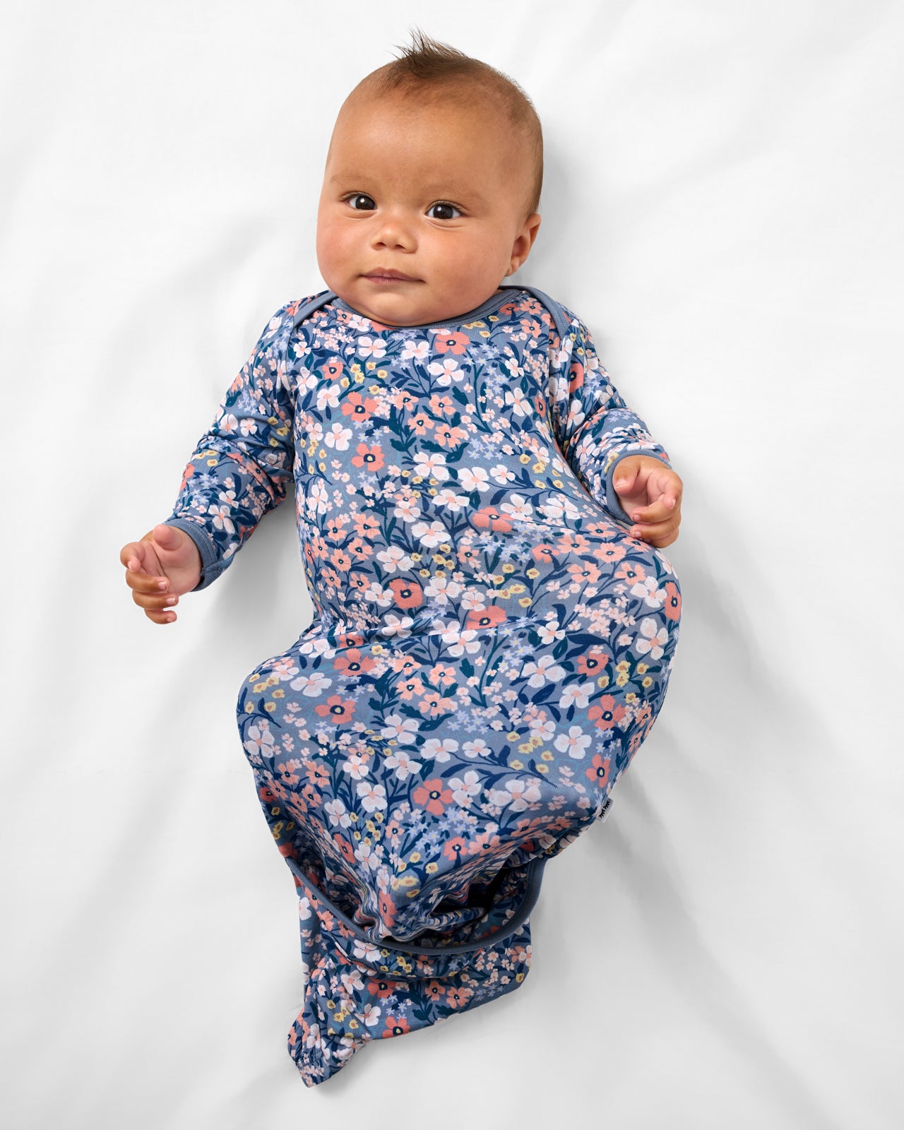 Aerial view of baby wearing the Petite Petals Infant Gown
