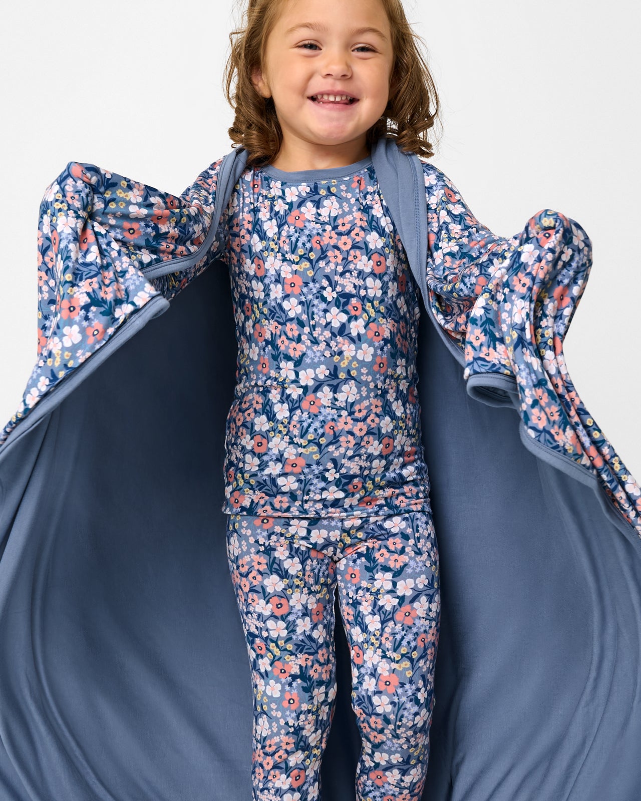 Close up of girl wrapped in the Petite Petals Large Cloud Blanket®