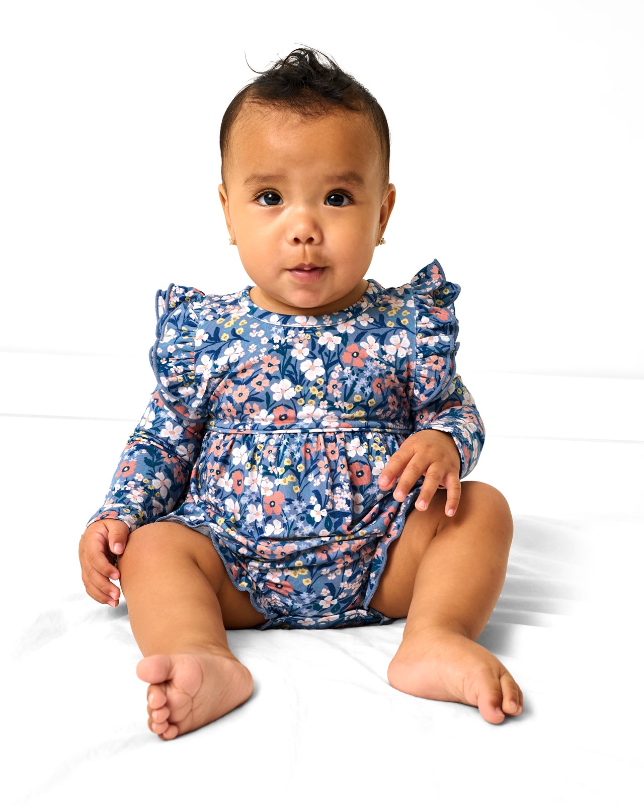 Sitting girl wearing the Petite Petals Bubble Romper