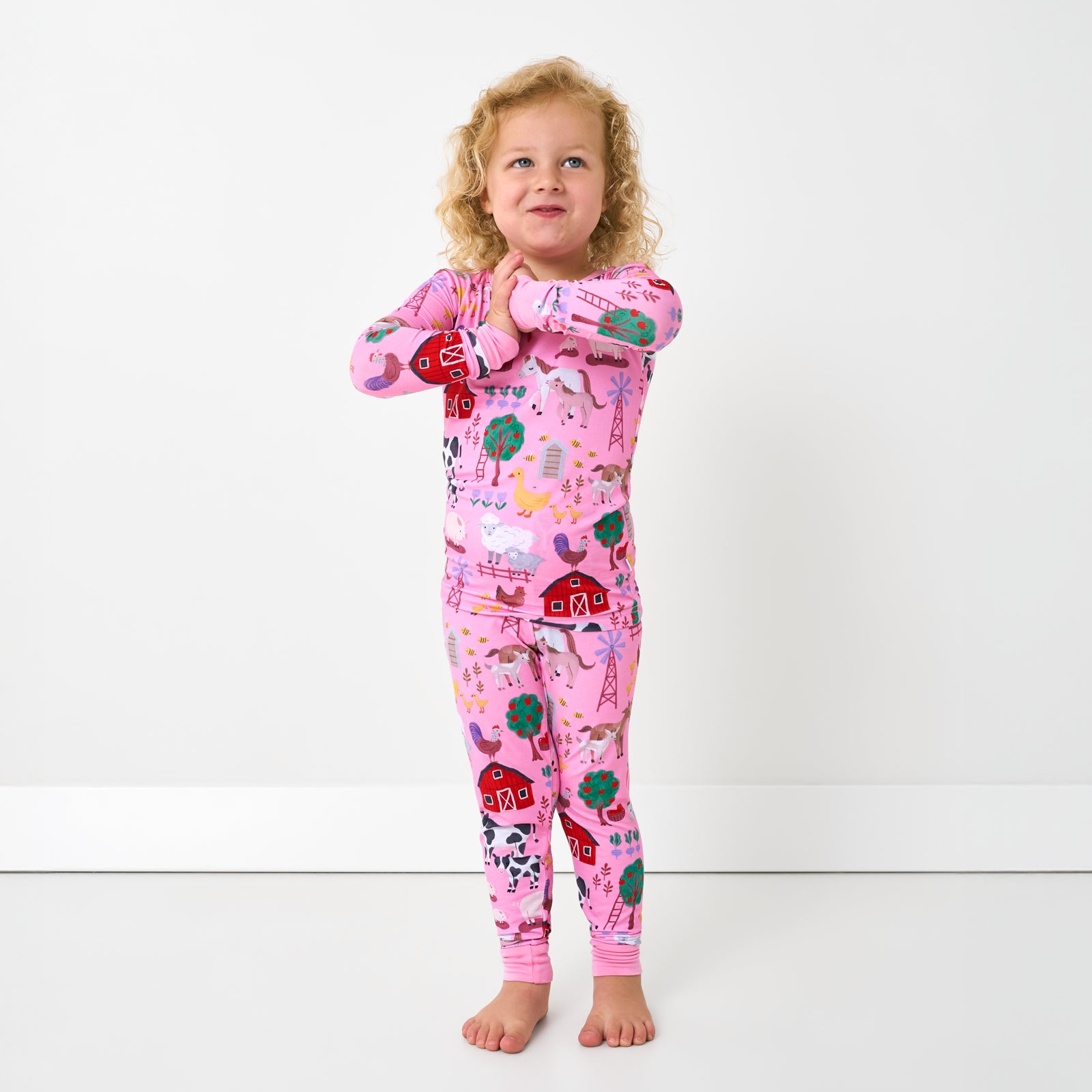 Standing child wearing the Pink Farm Fam Two-Piece Pajama Set