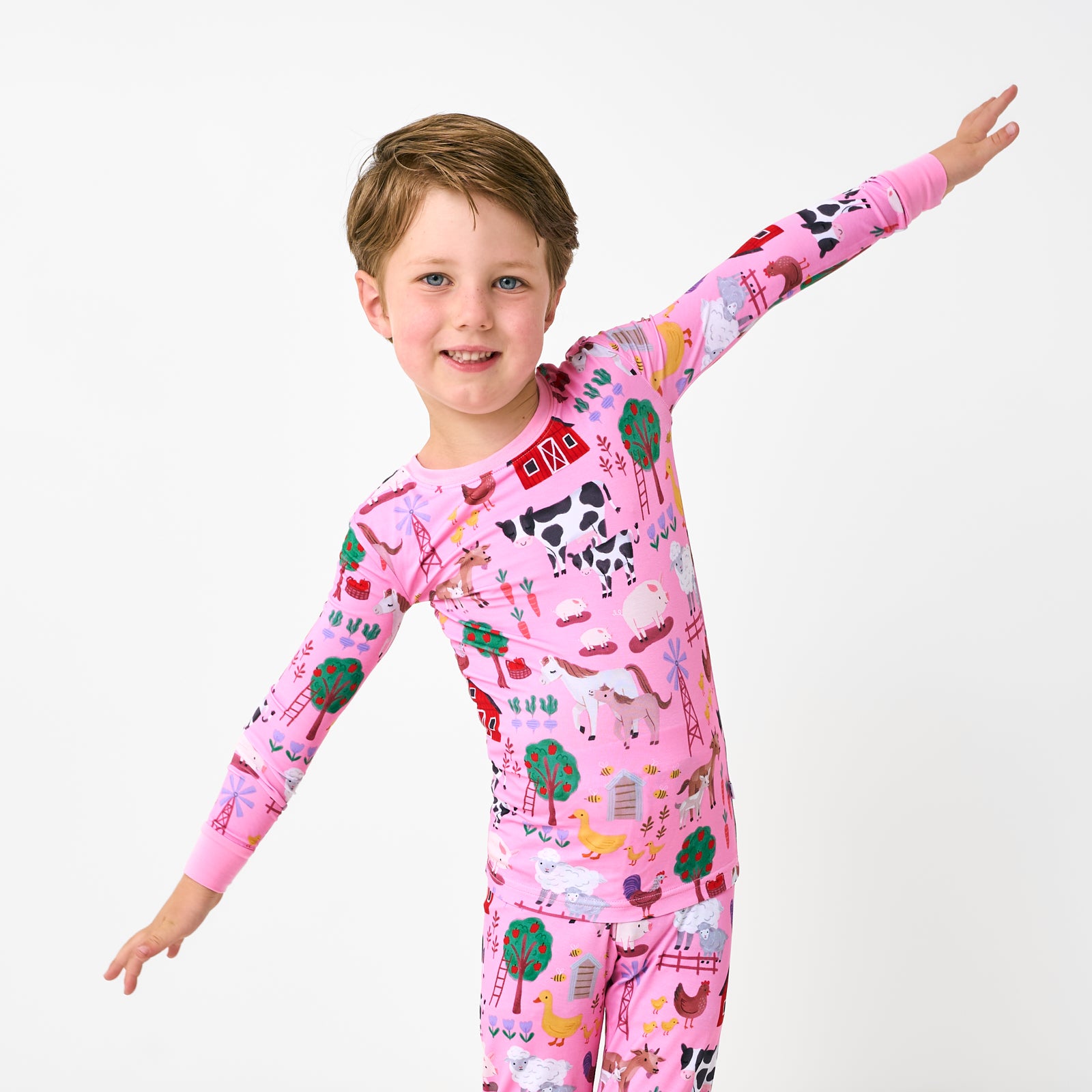Posing child wearing the Pink Farm Fam Two-Piece Pajama Set