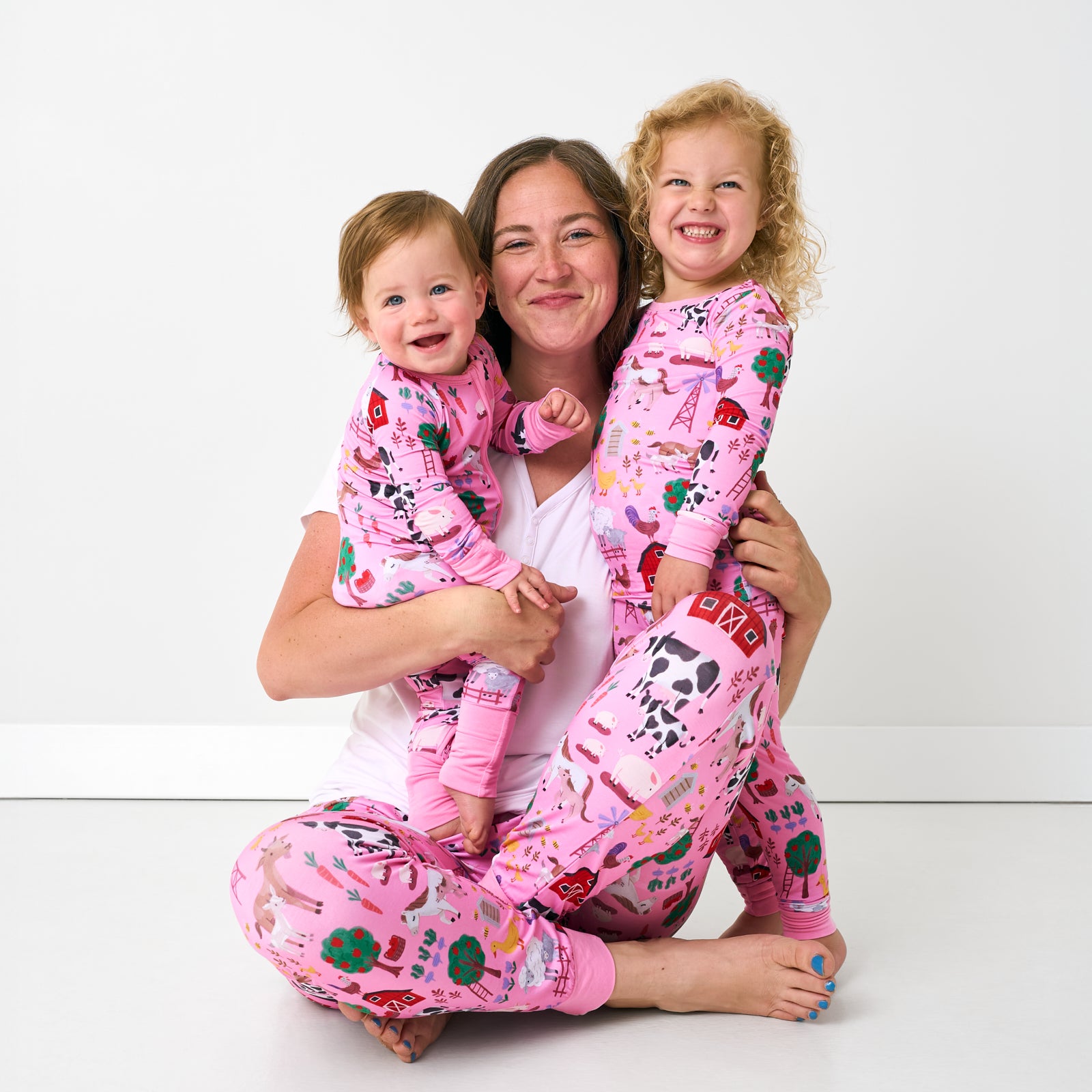 Mother and two children wearing matching Pink Farm Fam pajamas