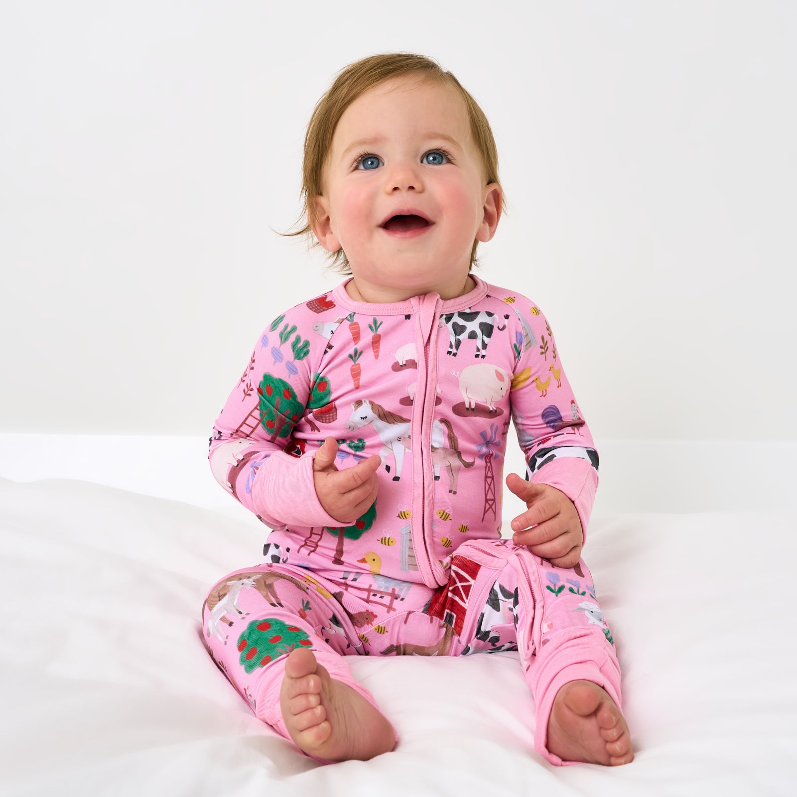 Sitting child wearing the Pink Farm Fam Zippy