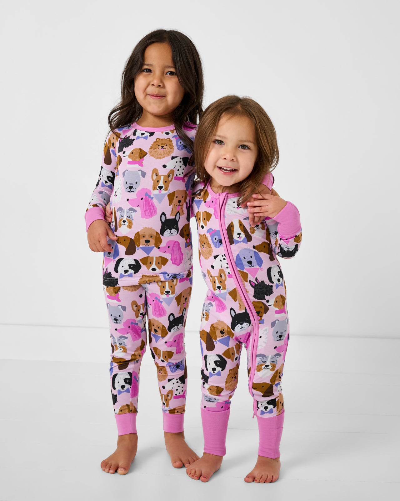 Two girls wearing matching Pink Puppy Parade bamboo pajamas