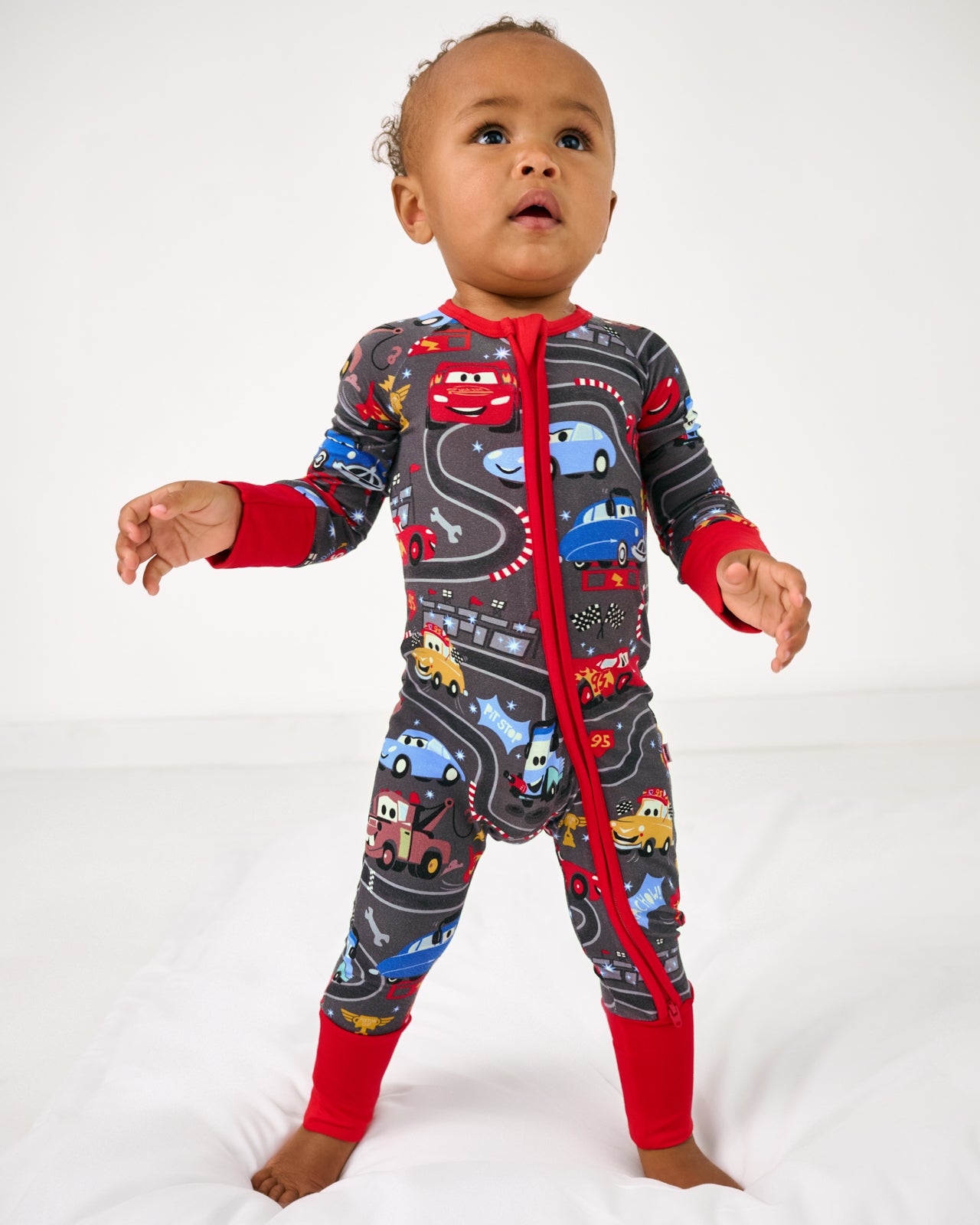 Standing baby wearing the Disney & Pixar Piston Cup Zippy