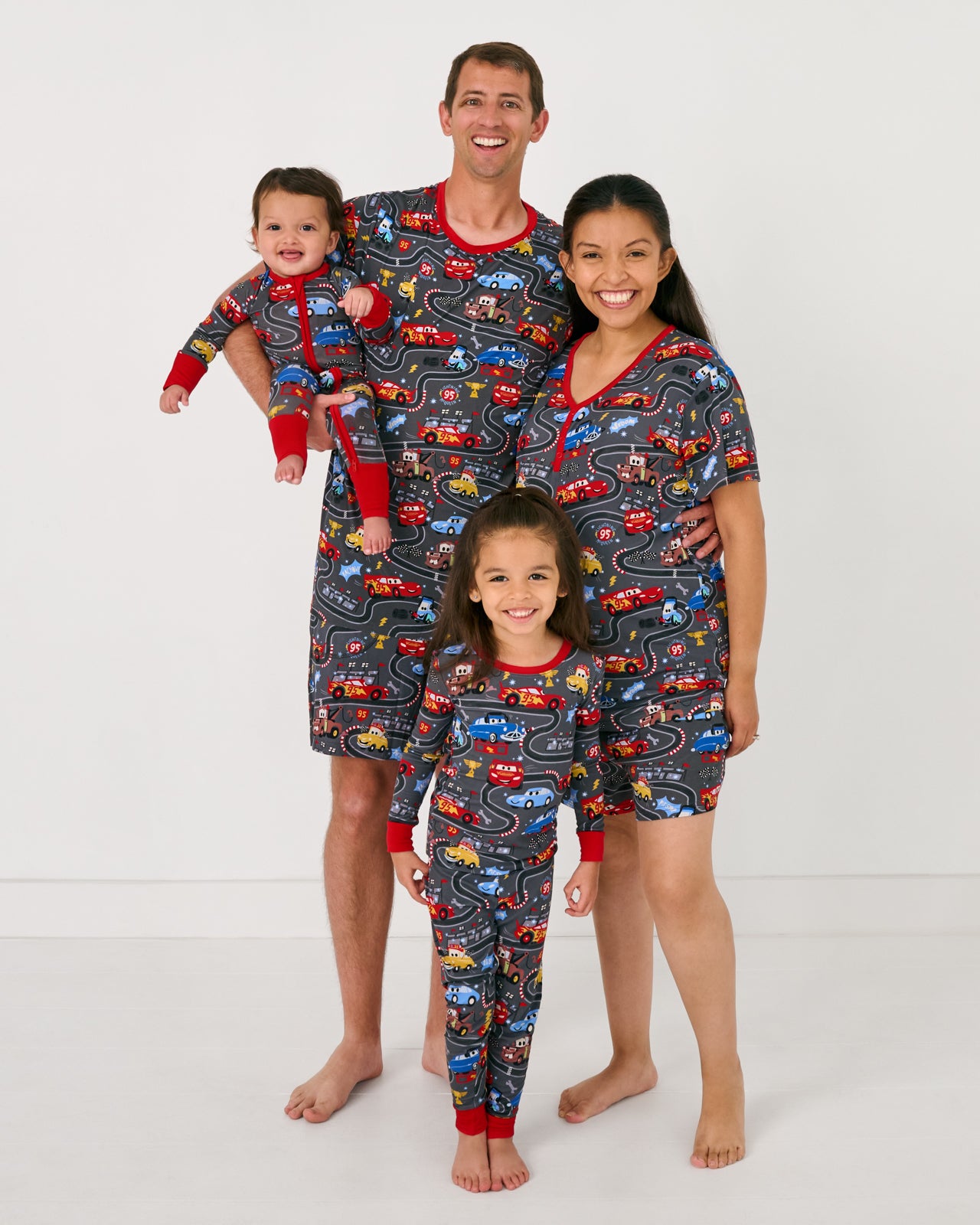 Family of four wearing matching Disney & Pixar Piston Cup pajamas