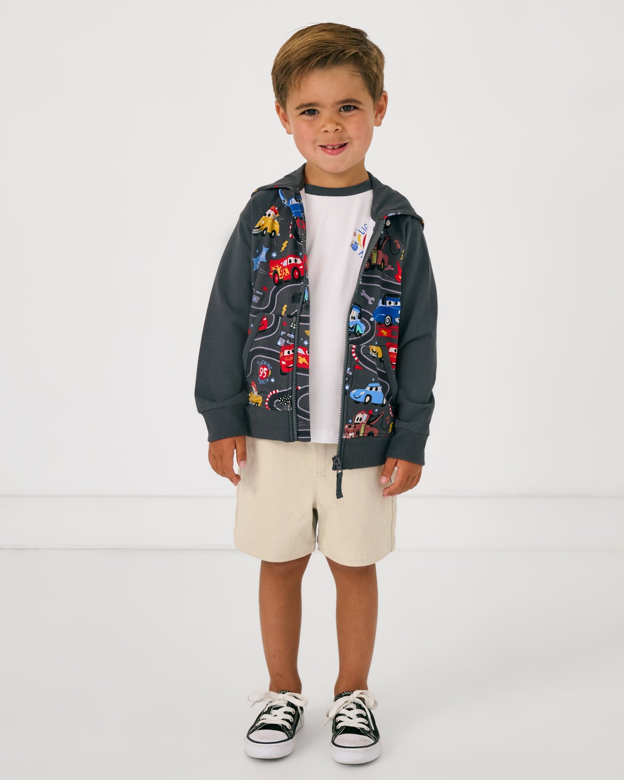 Alternate of boy wearing the Disney & Pixar Piston Cup Zip Hoodie layered over the Cars themed tee