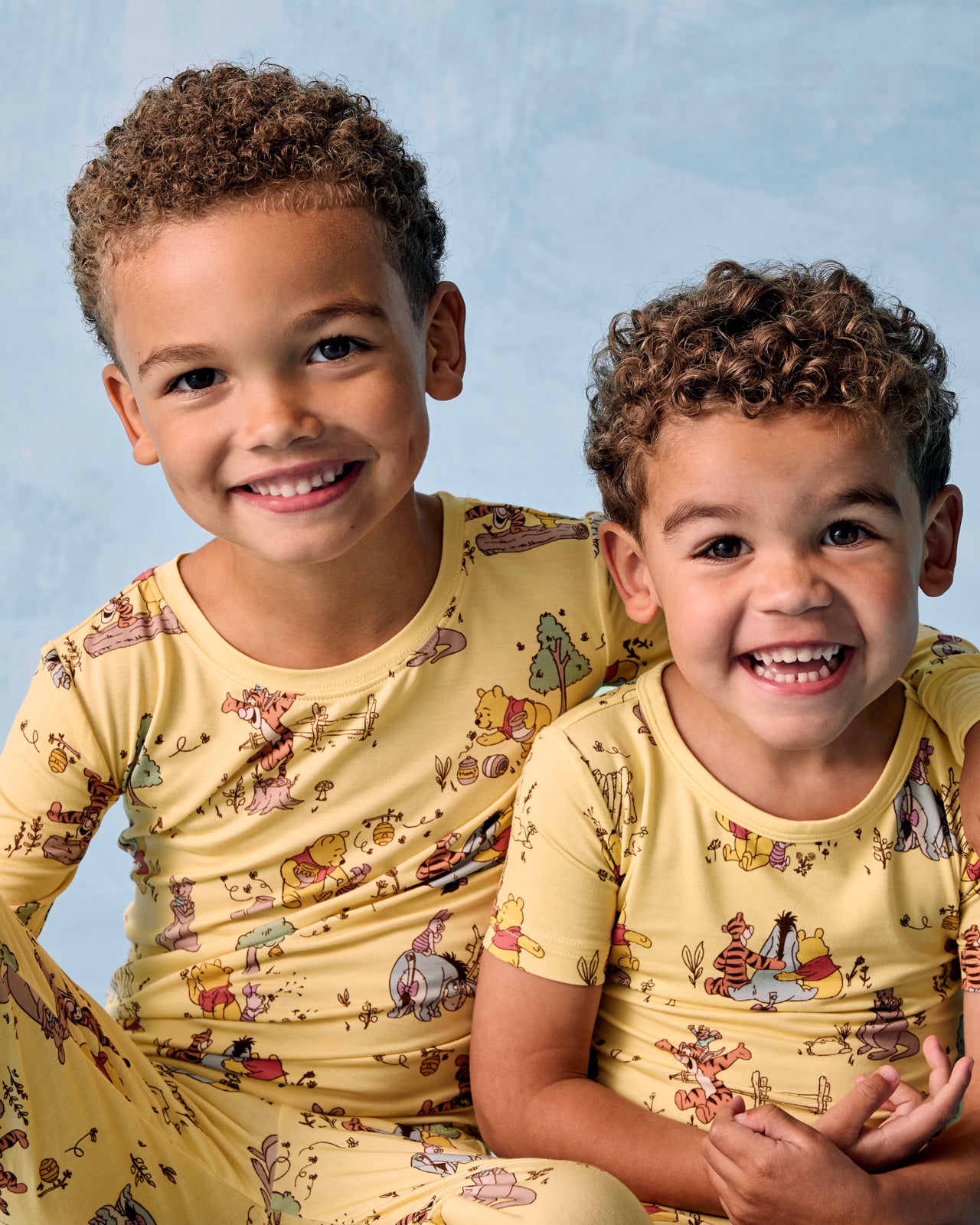 Two kids wearing matching Disney Playtime With Pooh Two-Piece Pajama Sets