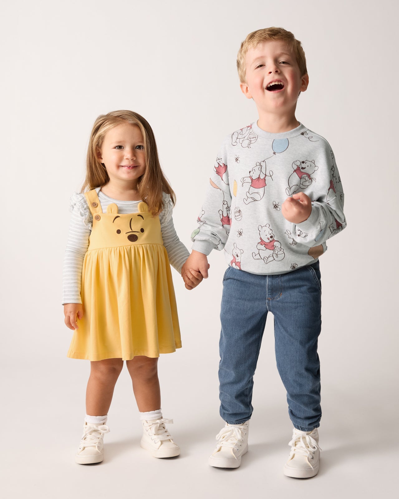 Two children wearing Winnie the Pooh themed play styles
