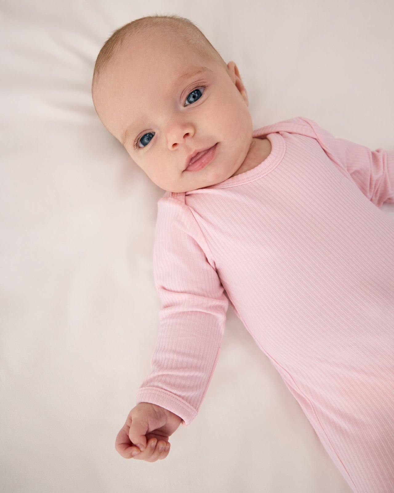 Close up of baby wearing the Prima Pink Ribbed Infant Gown