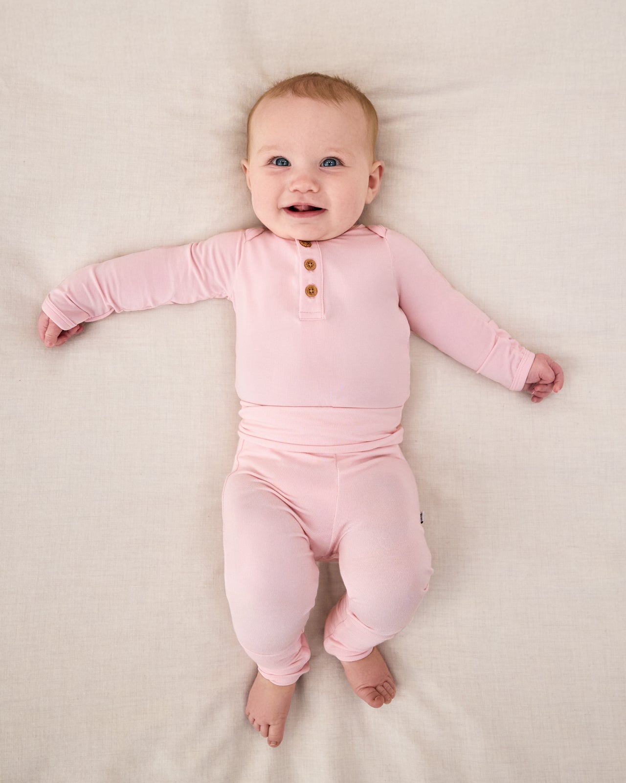 Newborn girl wearing the Prima Pink Henley Bodysuit