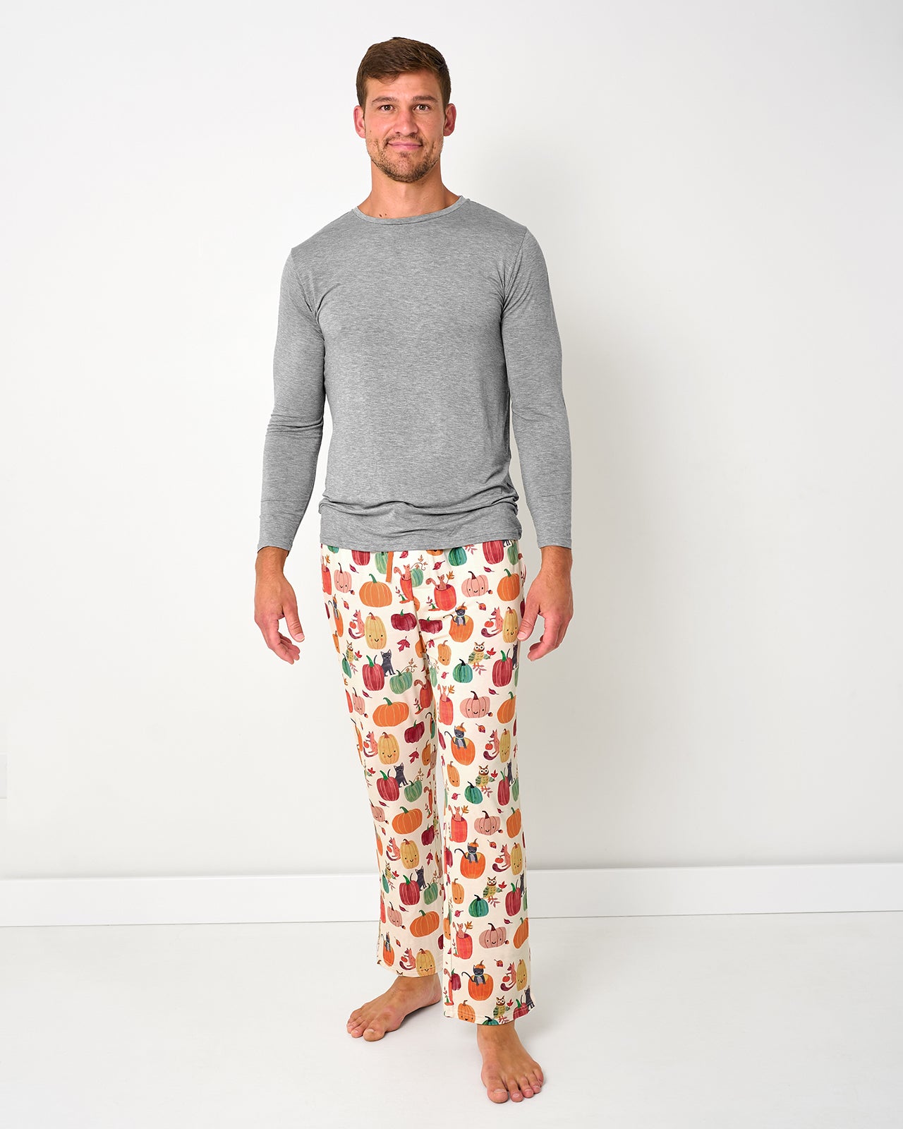 Standing man wearing the Pumpkin Pals Men's Pajama Pants with a gray pj top