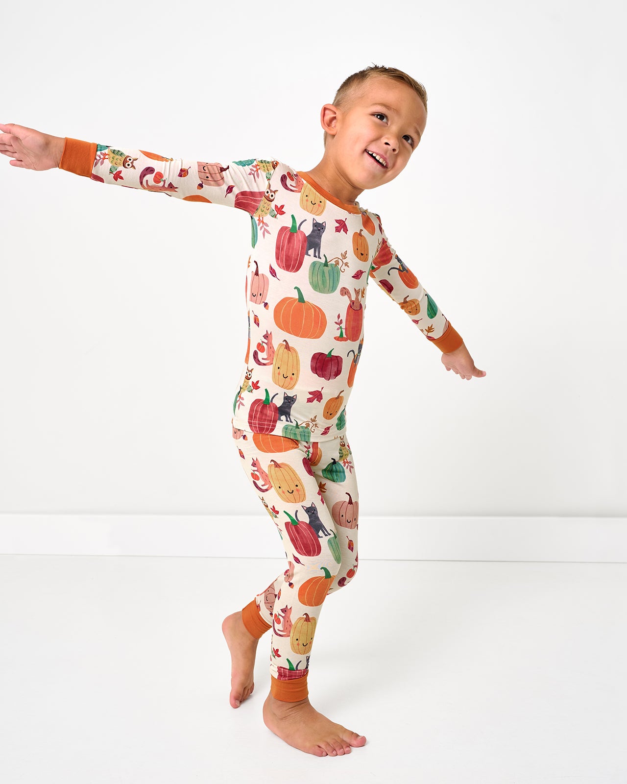 Posing child wearing the Pumpkin Pals Two-Piece Pajama Set