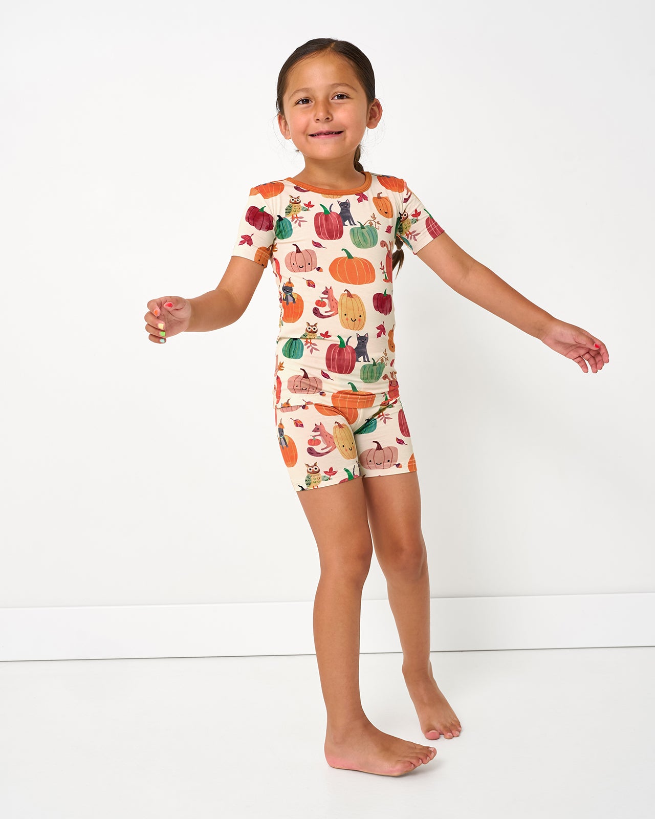 Standing girl wearing the Pumpkin Pals Two-Piece Short Sleeve & Shorts Pajama Set