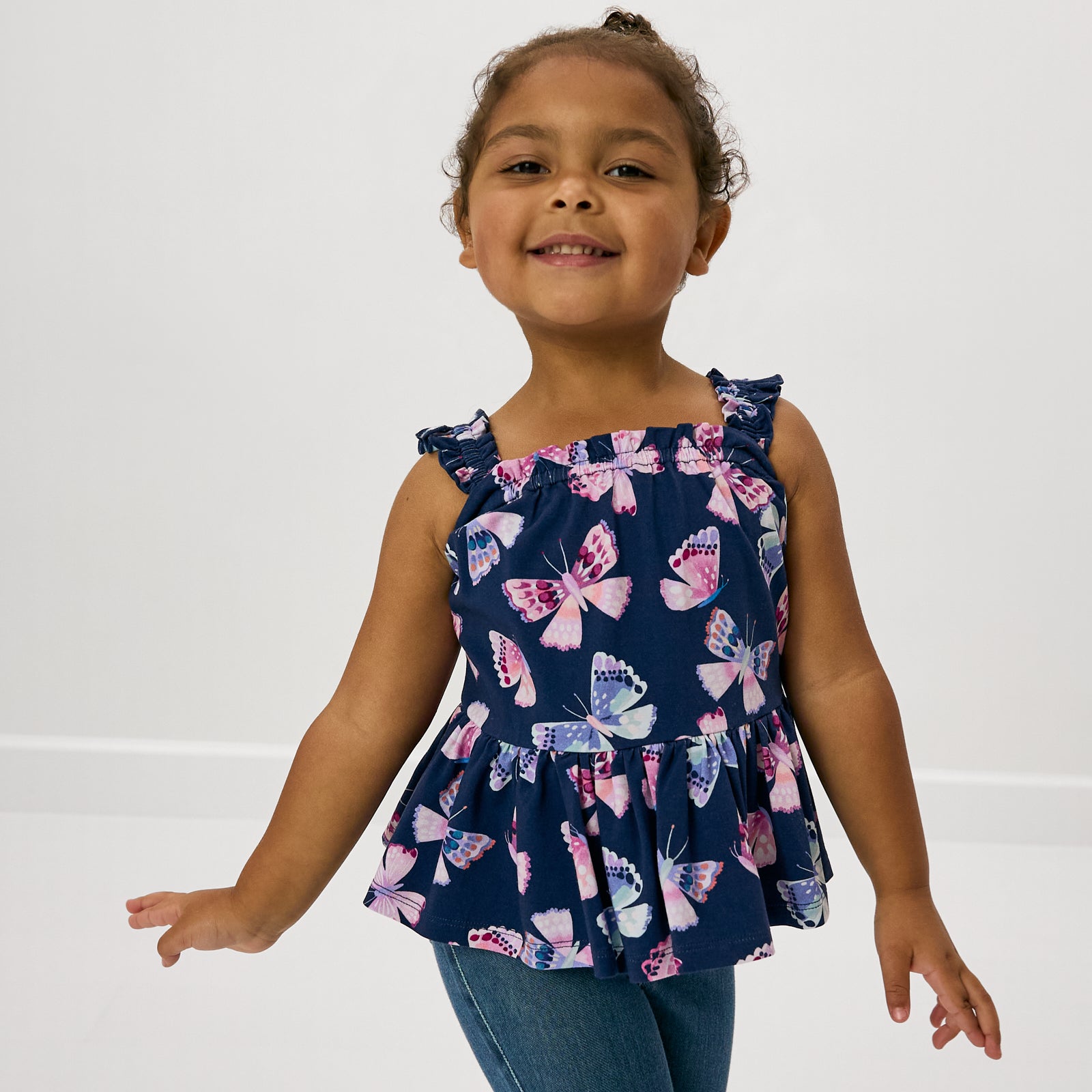 Close up of girl wearing the Royal Butterflies Peplum Flutter Tank
