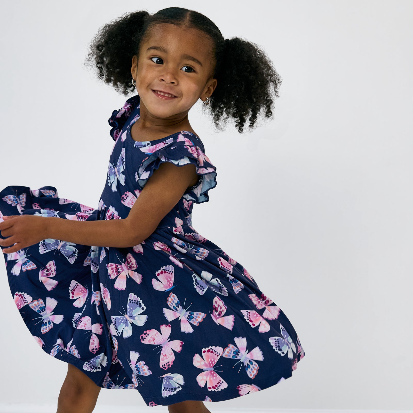 Twirling child wearing the Royal Butterflies Flutter Twirl Dress