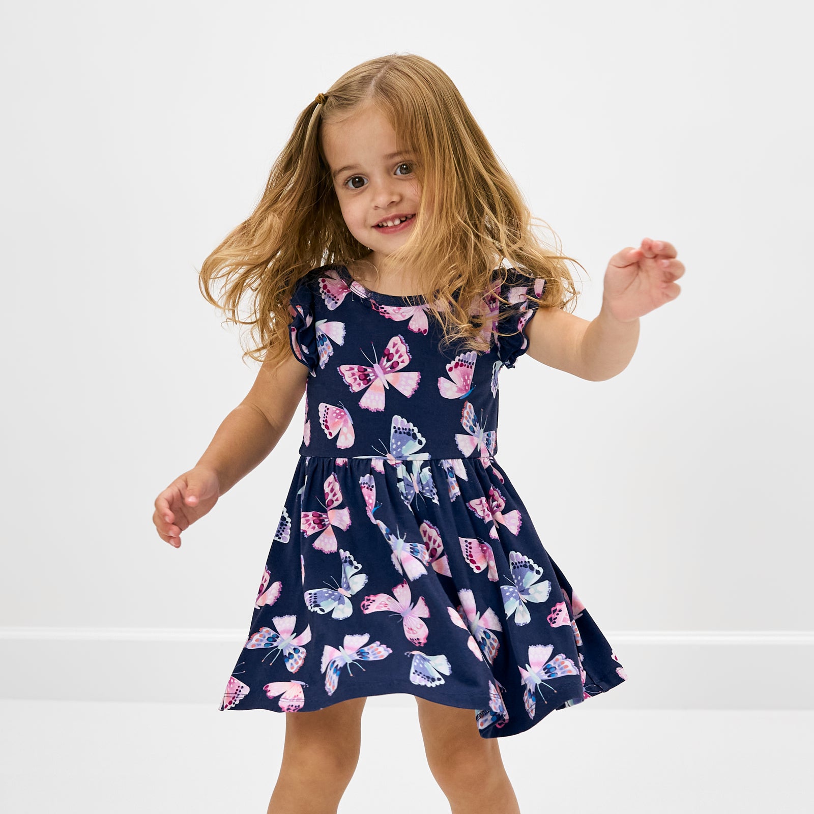 Standing toddler wearing the Royal Butterflies Flutter Twirl Dress with Bodysuit