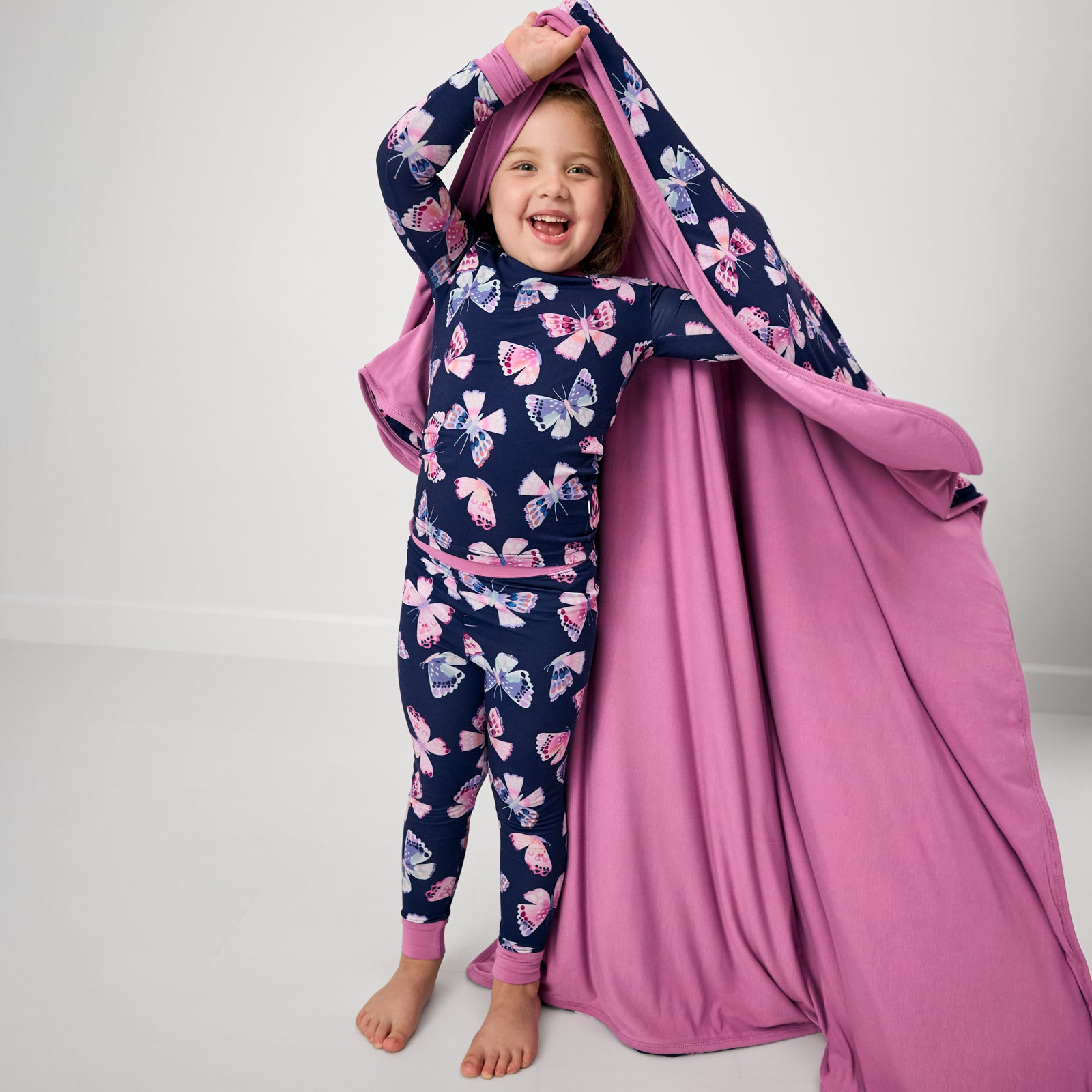 Girl holding up the Royal Butterflies Large Cloud Blanket® showing the solid lilac side