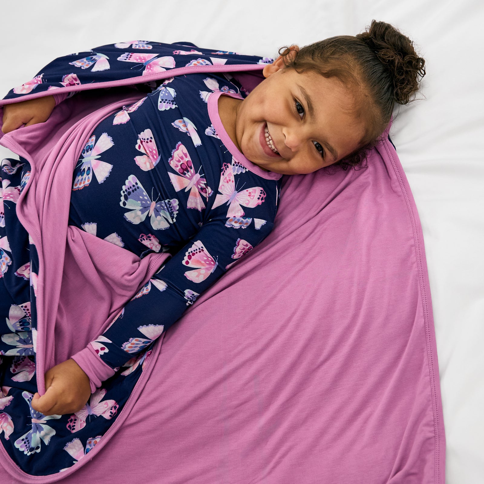 Aerial view of girl wrapped in the Royal Butterflies Large Cloud Blanket®