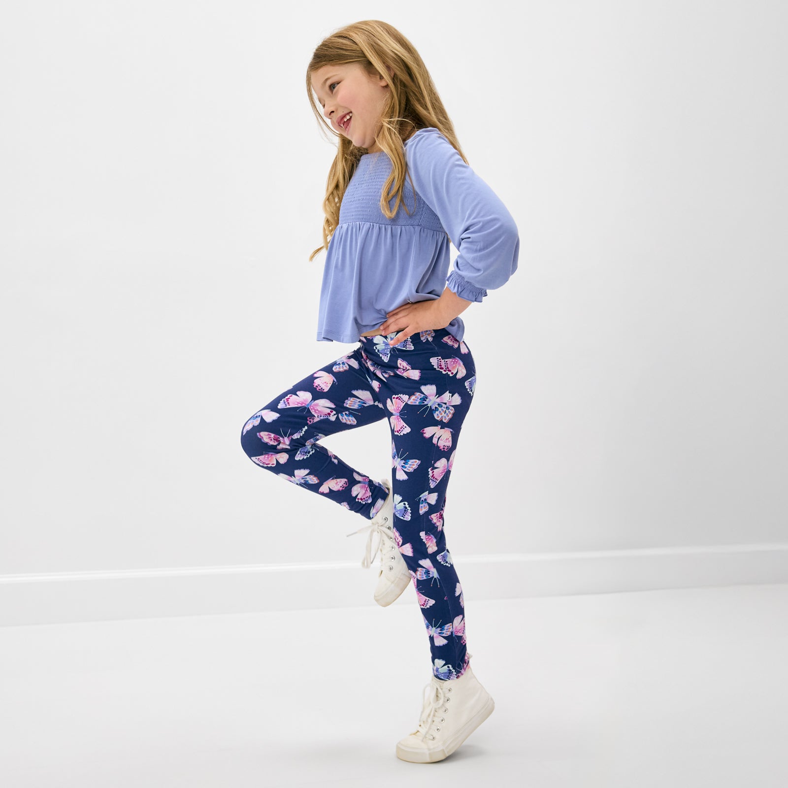 Child in motion wearing the Royal Butterflies Legging with a matching purple girls shirt