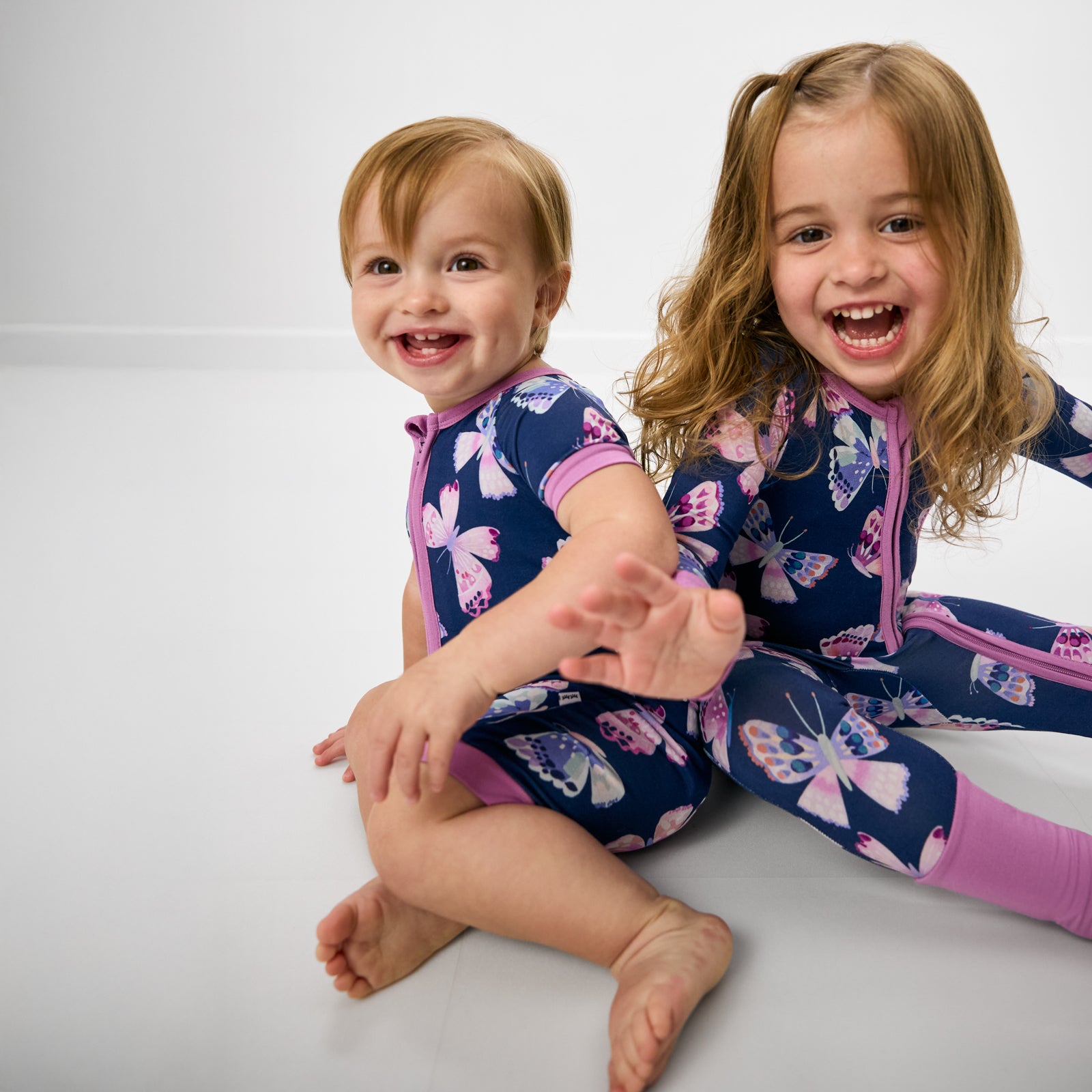 Two children wearing matching Royal Butterflies butterfly print pajamas for kids