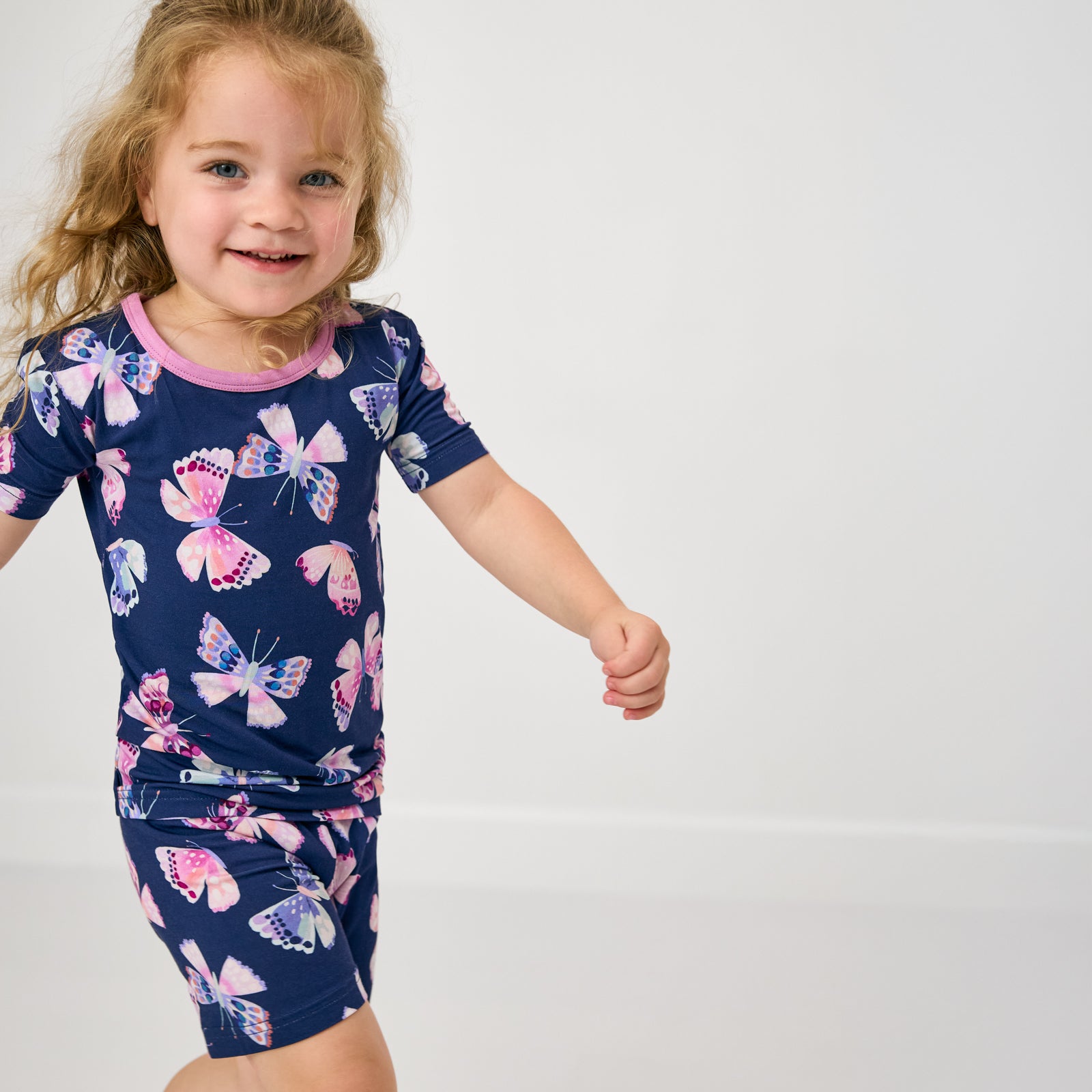 Close up of child wearing the Royal Butterflies Two-Piece Short Sleeve & Shorts Pajama Set