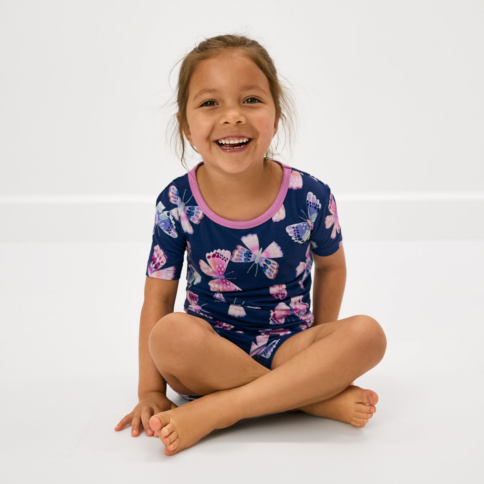 Sitting girl wearing the Royal Butterflies Two-Piece Short Sleeve & Shorts Pajama Set