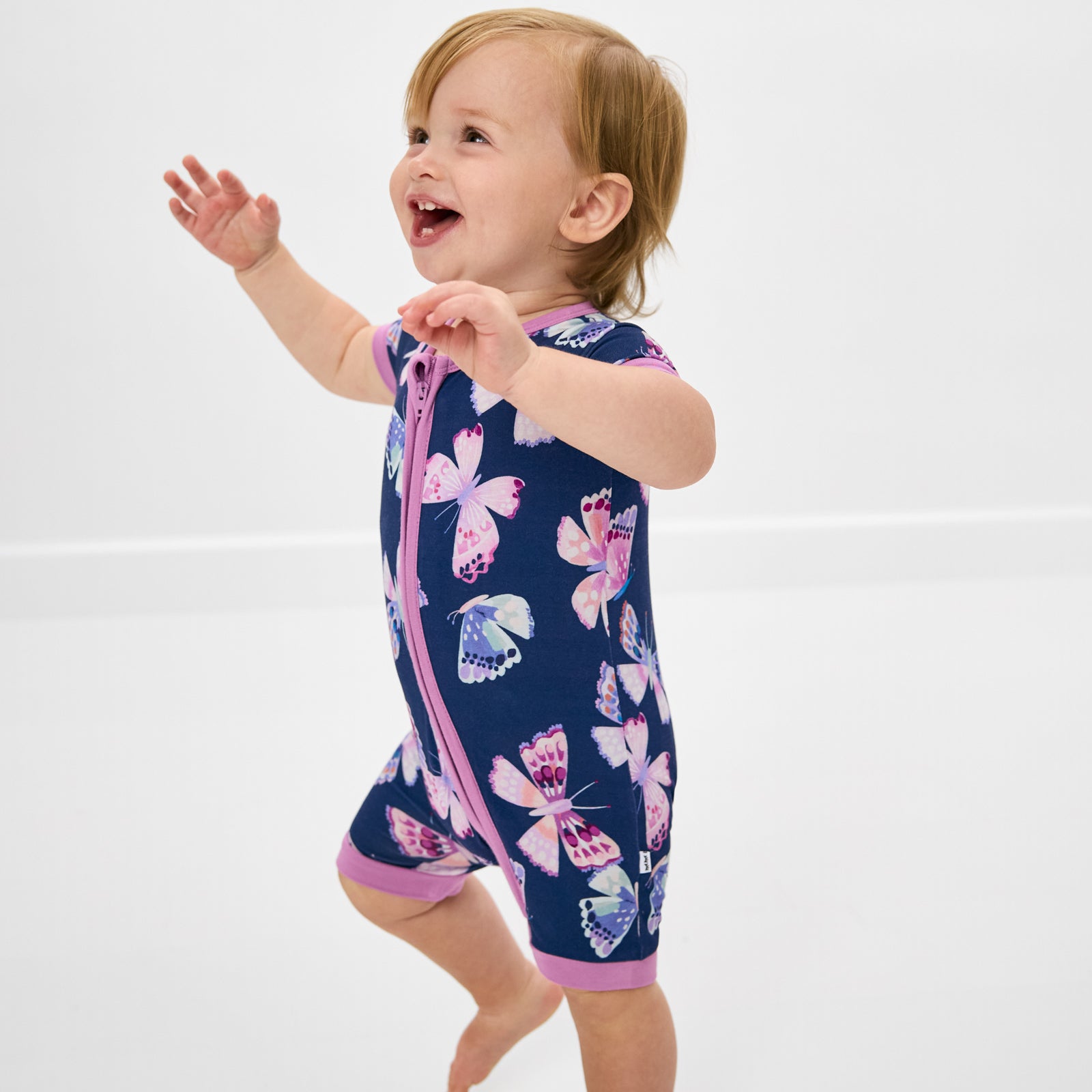 Toddler wearing the Royal Butterflies butterfly print zipper pajamas