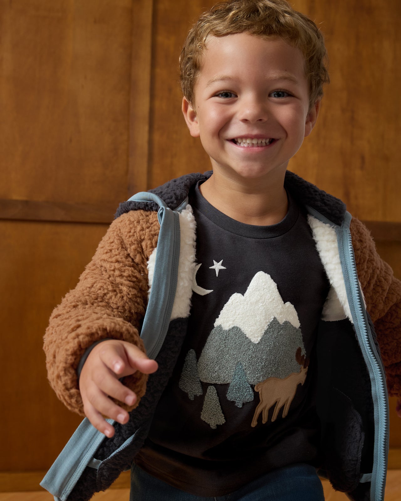 Boy wearing the Moose Trail Long Sleeve Relaxed Tee layered under a sherpa jacket