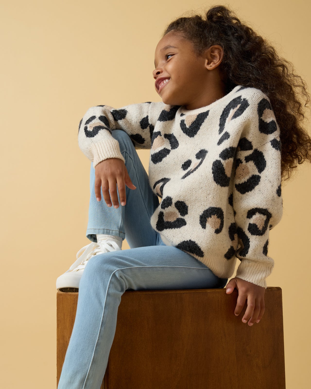 Girl wearing the Snowy Leopard Drop Shoulder Sweater with denim pants