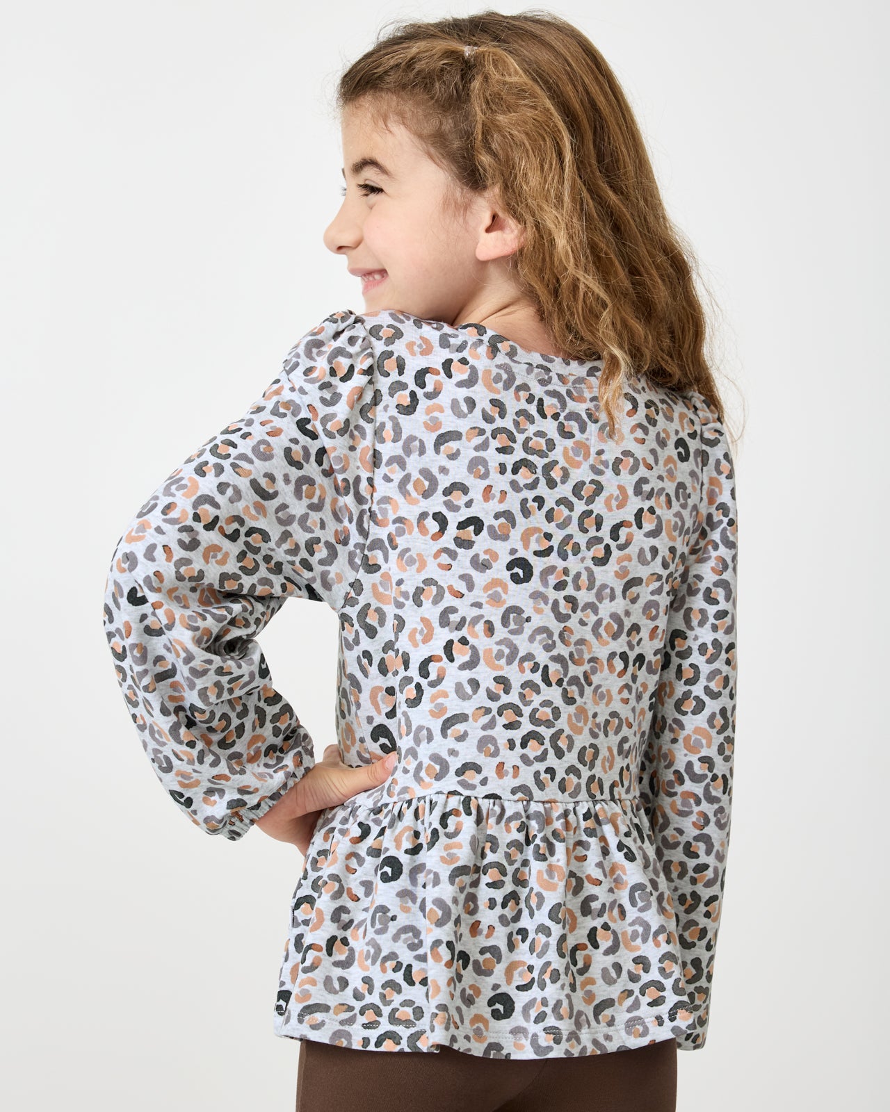 Back view of girl wearing the Snowy Leopard Puff Sleeve Peplum Top