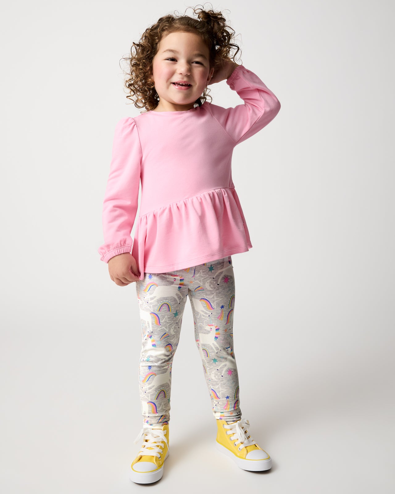 Standing girl wearing the Unicorn Dance Legging with a pink top