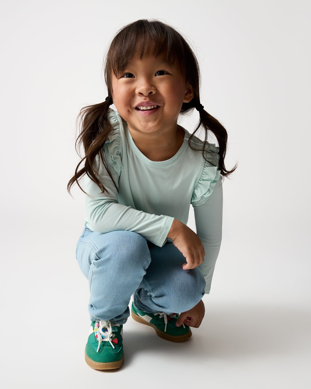 Girl wearing the Mint Mist Flutter Tee with green sneakers