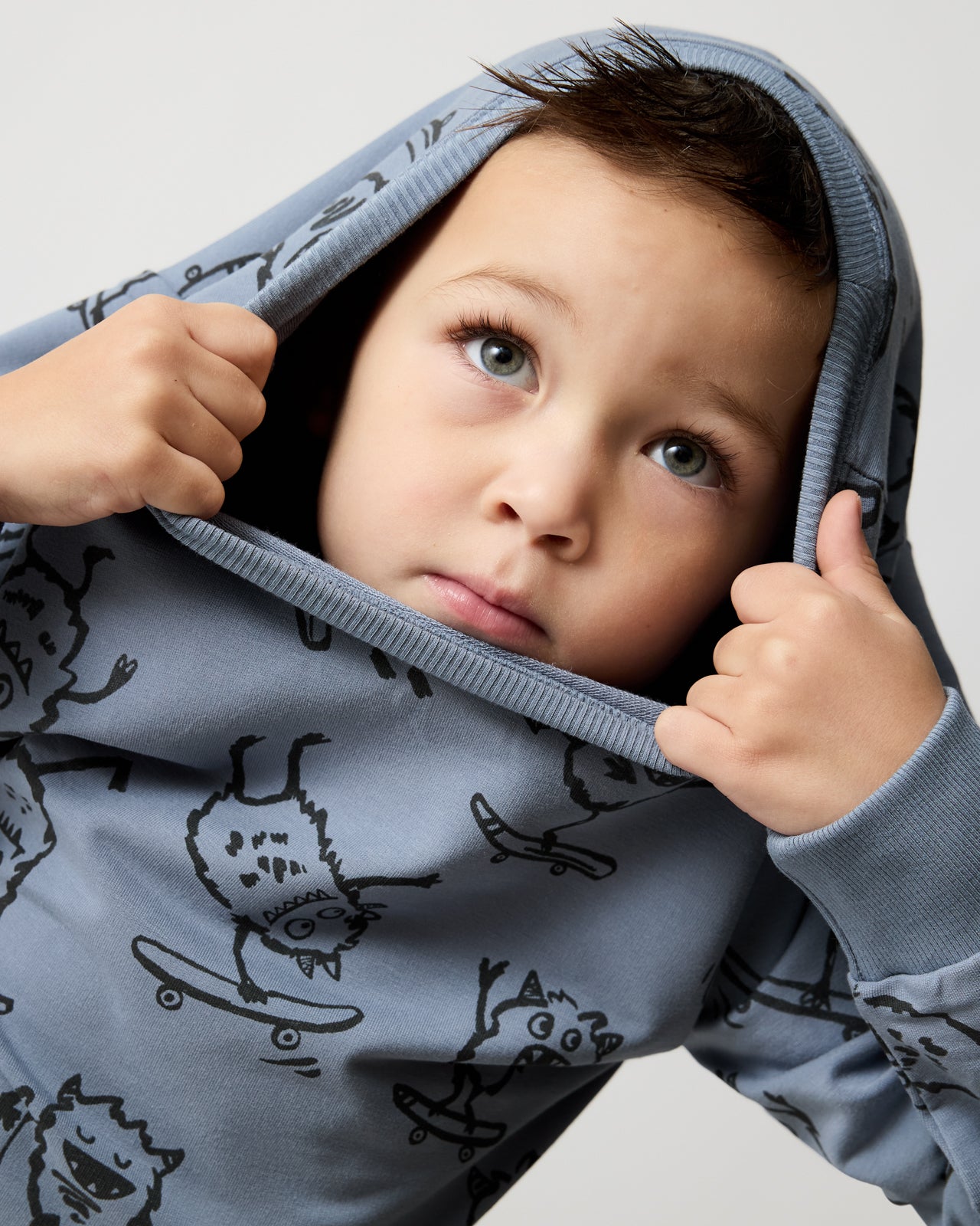 Boy wearing the Monster Moves Crewneck Sweatshirt poking his head through the neck opening