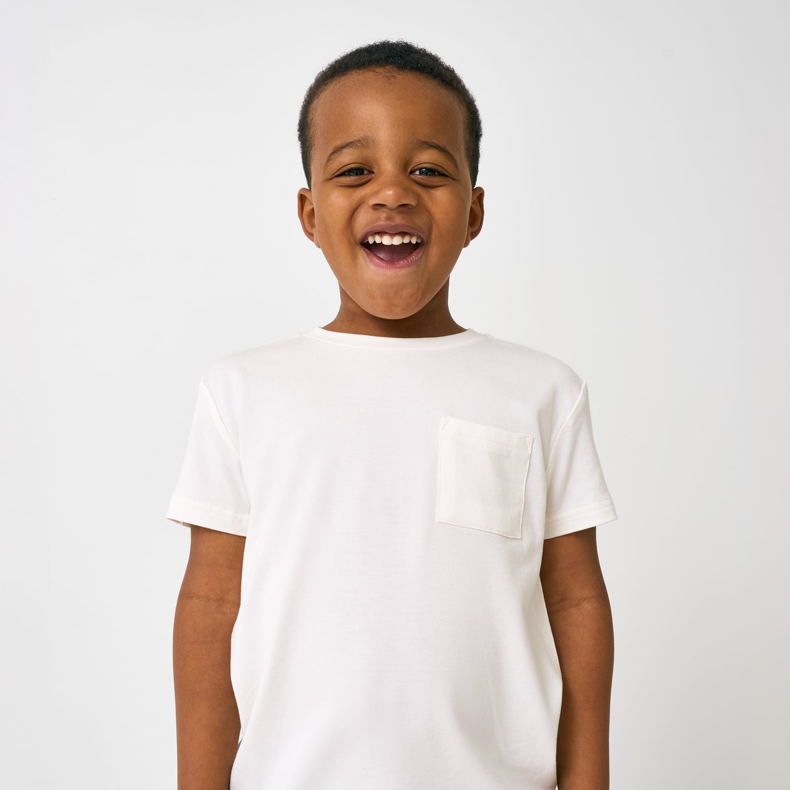 Close up of child wearing the Soft White Short Sleeve Relaxed Pocket Tee