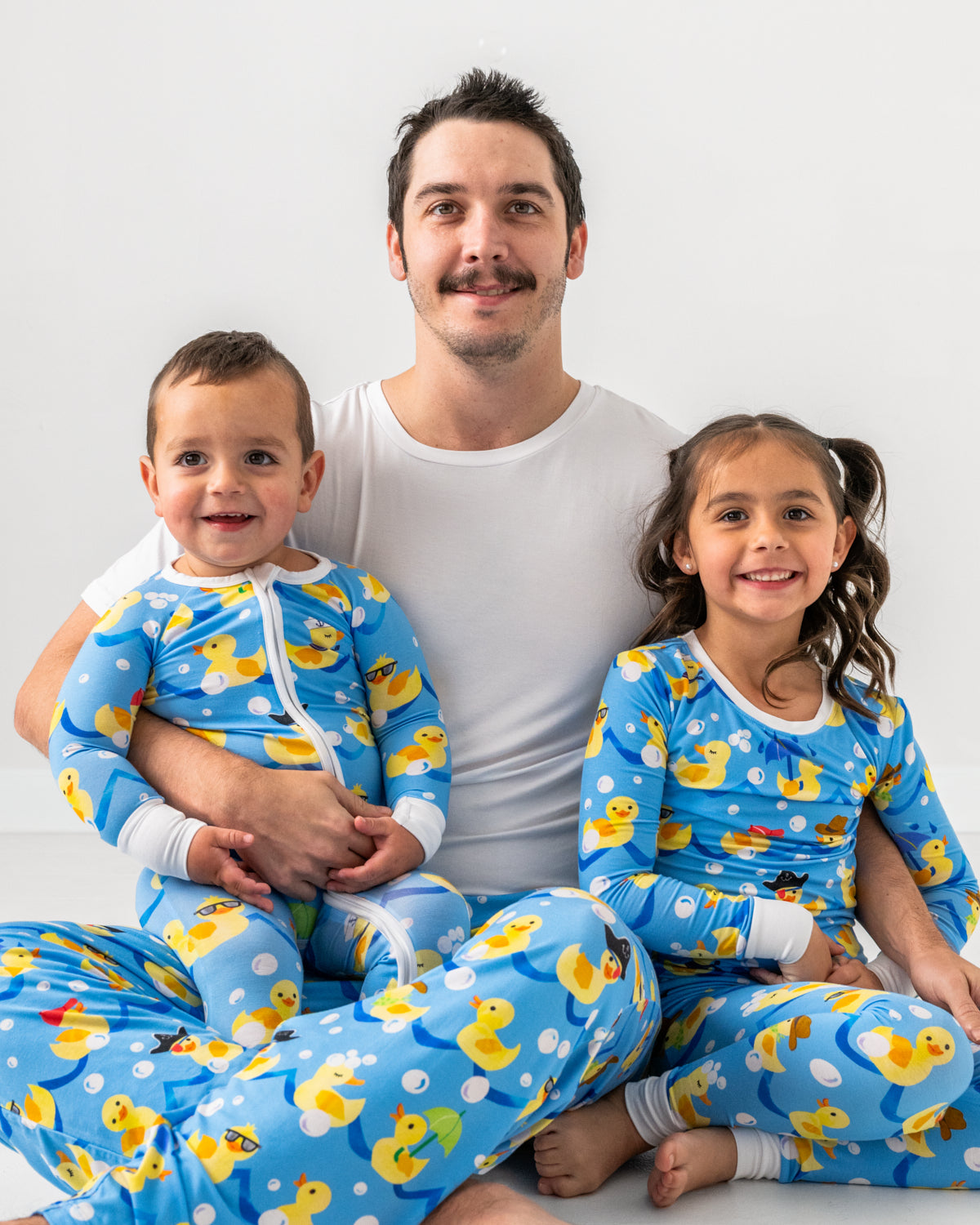 Father and two children wearing matching Splish Splash pajamas