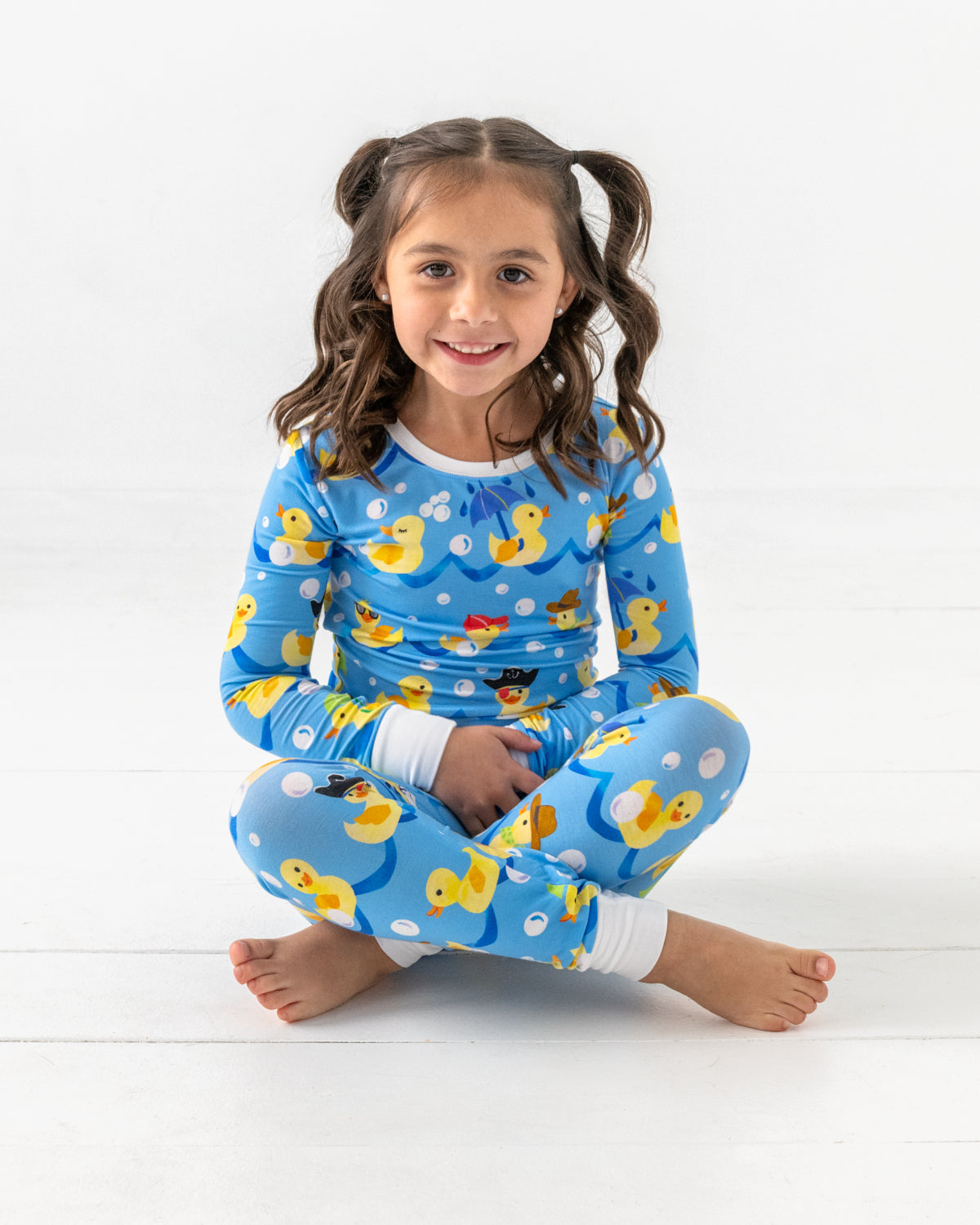Sitting girl wearing the Splish Splash Two-Piece Pajama Set