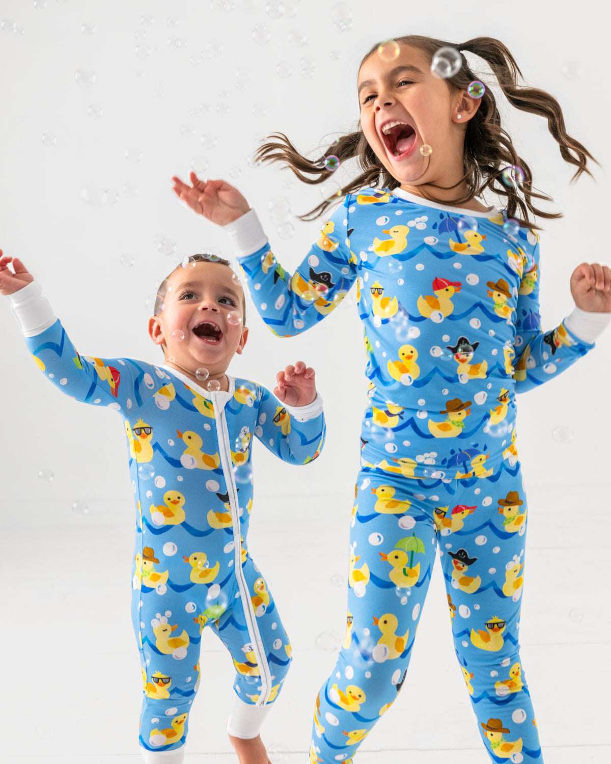 Two children wearing Splish Splash pajamas playing with bubbles