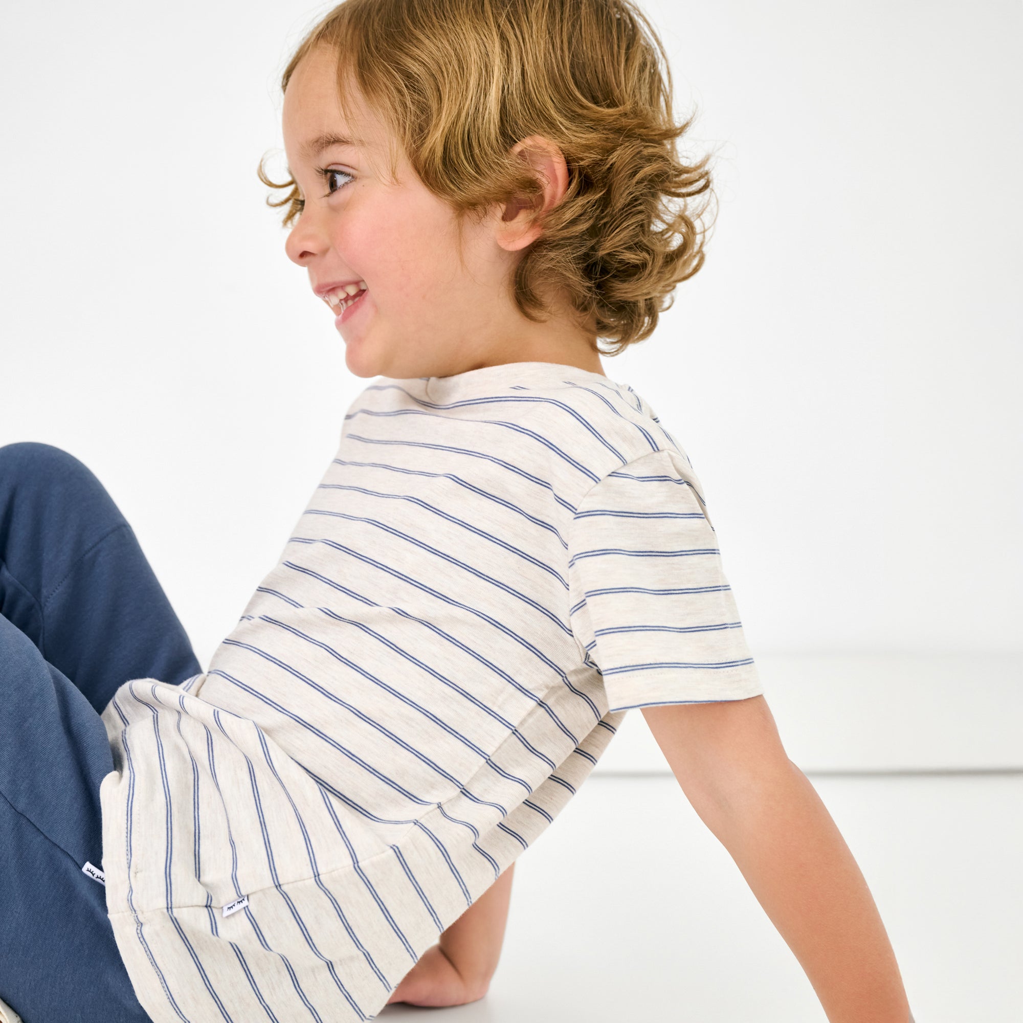 Sitting child wearing the Stone Stripes Short Sleeve Relaxed Tee